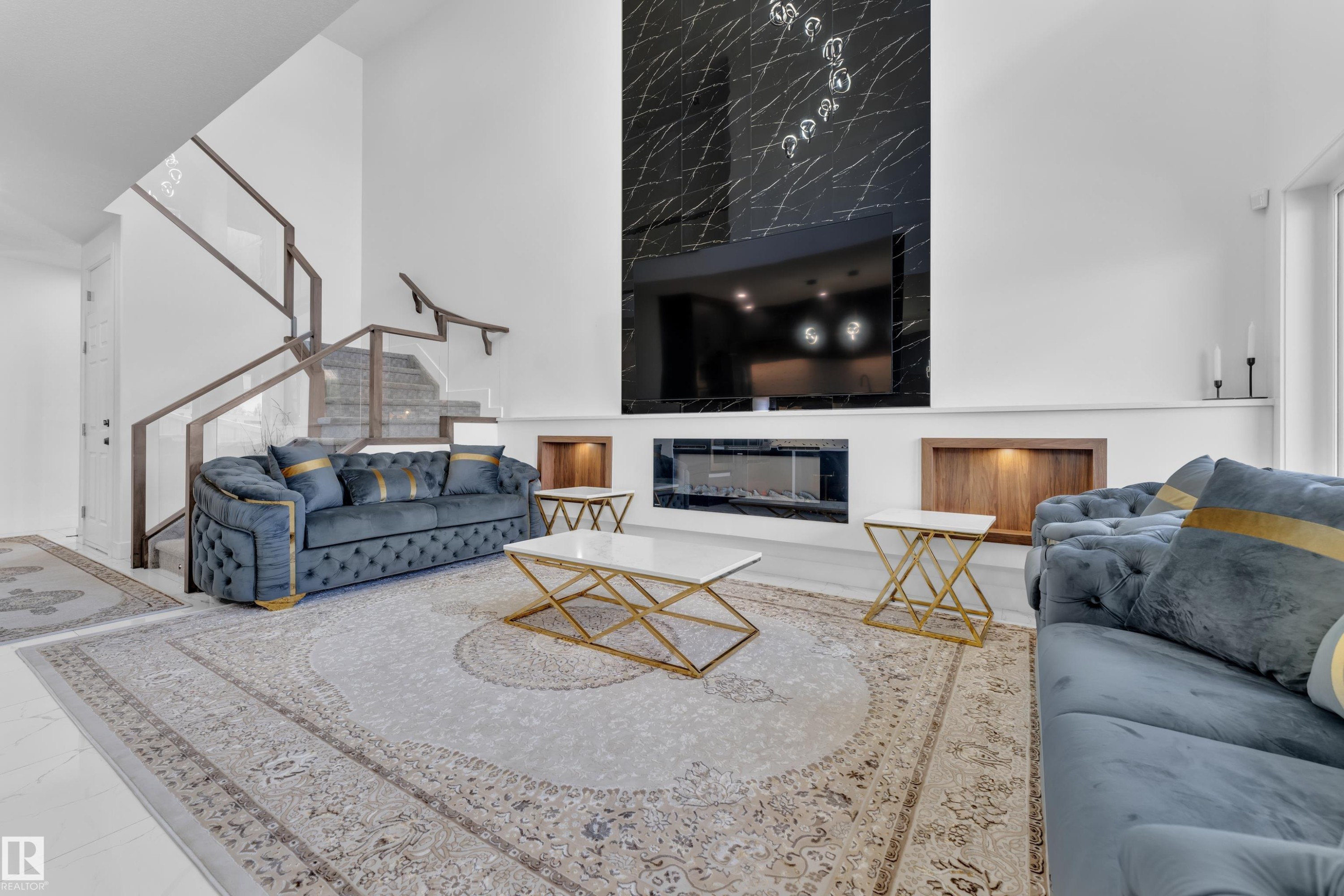 Two-story living area featuring a prominent black stone-finish accent wall with a built-in electric fireplace - 16816 49 Street, Edmonton, AB