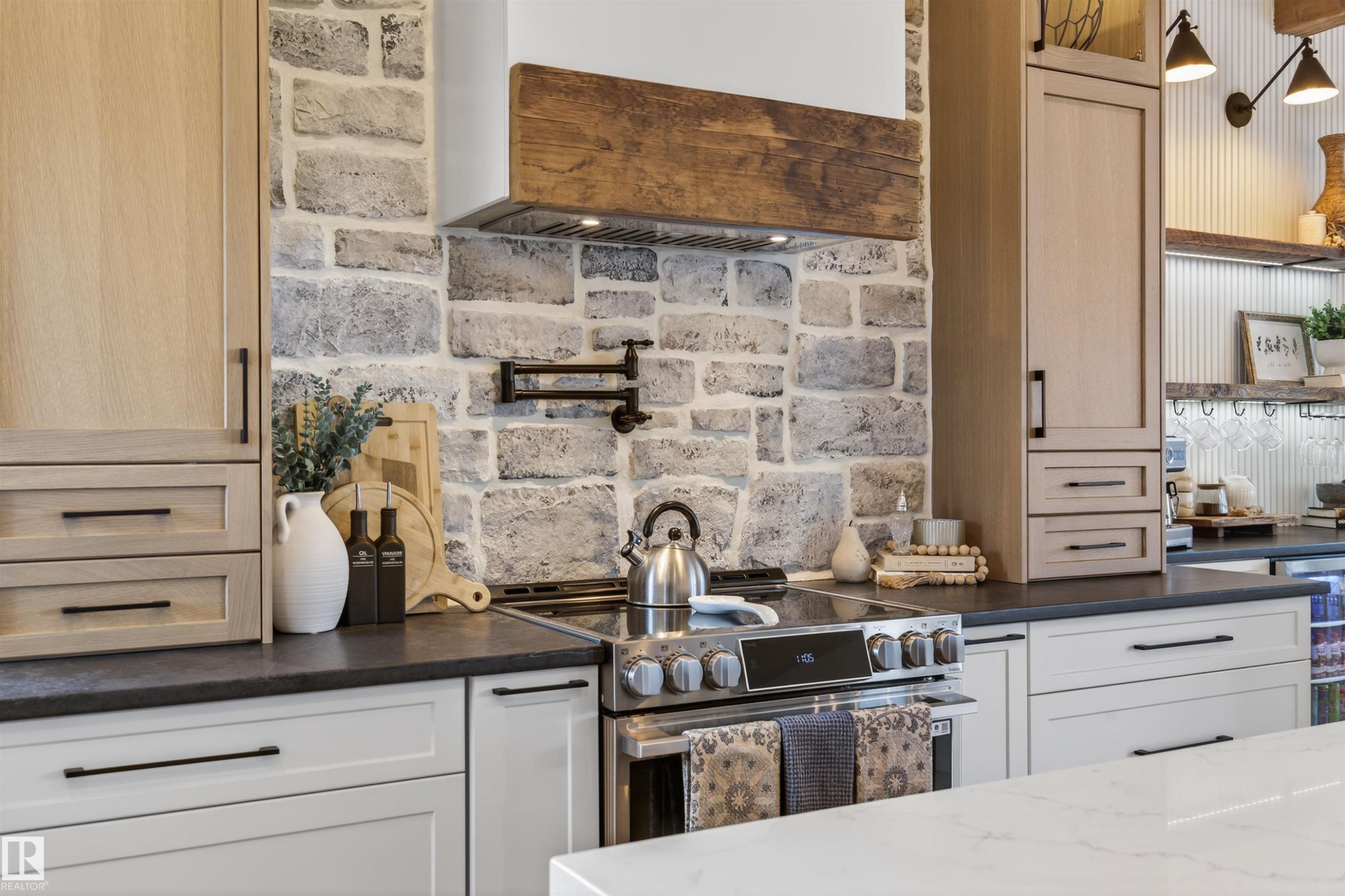 Kitchen featuring stone backsplash, wood-finish cabinetry, black countertops, and stainless steel range - 711 Beach Avenue, Cold Lake, AB - Indoor Photo Showing Kitchen With Upgraded Kitchen