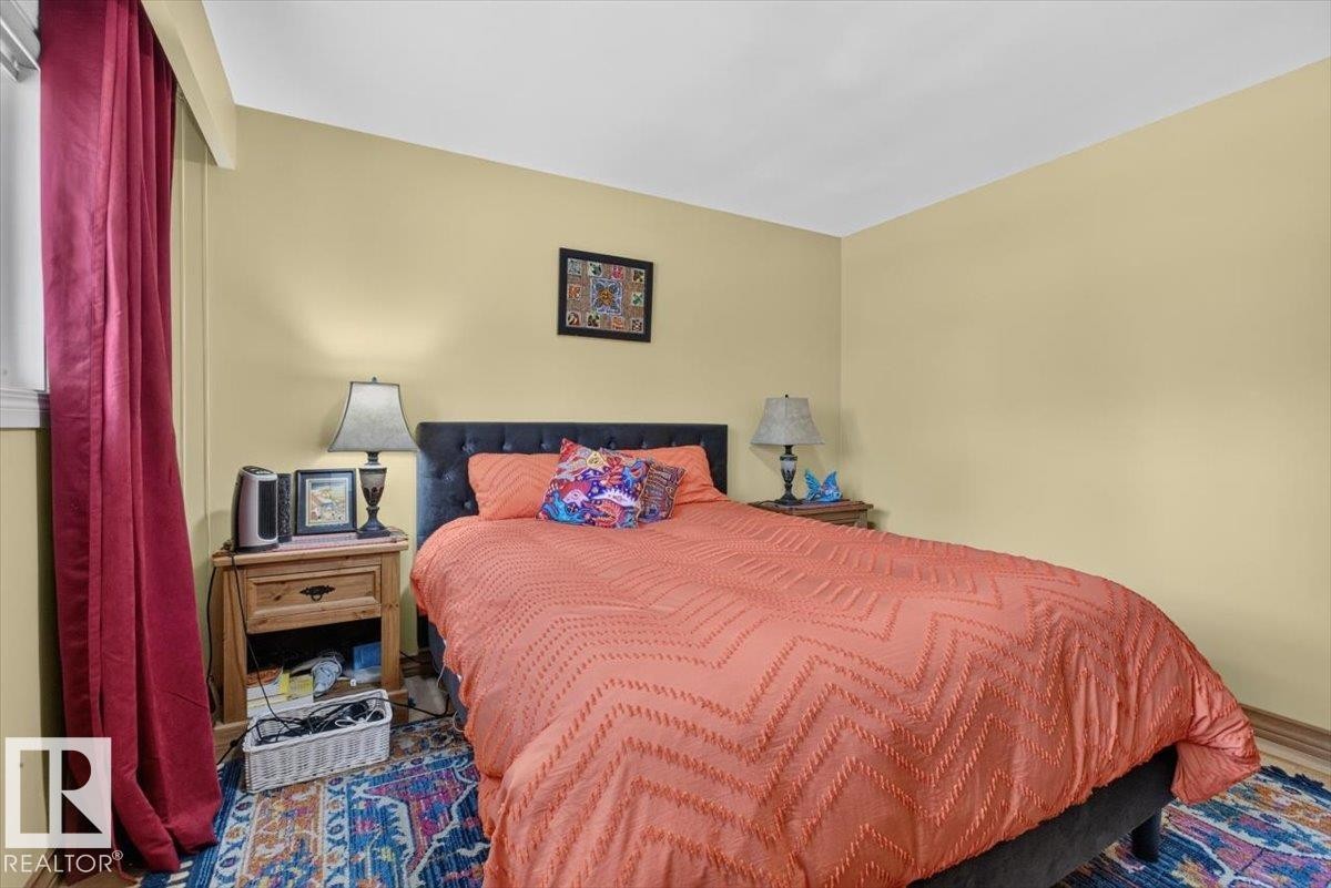 Bedroom featuring light yellow walls and wood-finish flooring - 10736 48 Street Nw, Edmonton, AB - Indoor Photo Showing Bedroom
