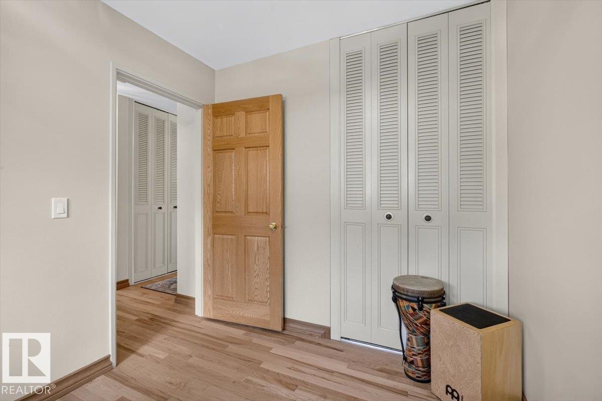 Wood-finish flooring throughout - 10736 48 Street Nw, Edmonton, AB - Indoor Photo Showing Other Room