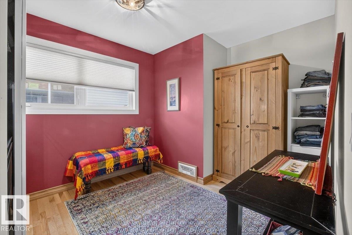 Room featuring hardwood flooring, a white-framed window with blinds, and recessed lighting - 10736 48 Street Nw, Edmonton, AB - Indoor