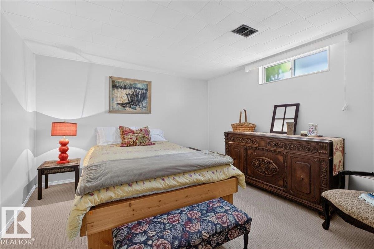 Carpeted room featuring light-colored walls and a drop ceiling - 10736 48 Street Nw, Edmonton, AB - Indoor Photo Showing Bedroom