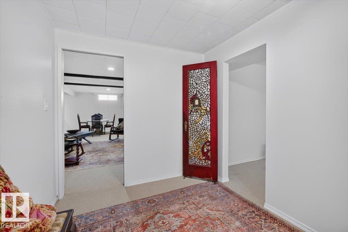 Interior hallway featuring a decorative stained-glass door, white painted walls, and a recessed ceiling with acoustic panels - 10736 48 Street Nw, Edmonton, AB - Indoor Photo Showing Other Room