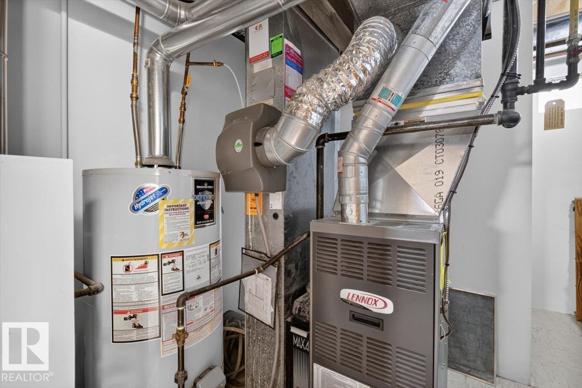 Lennox furnace and water heater with associated ductwork and piping - 10736 48 Street Nw, Edmonton, AB - Indoor Photo Showing Basement