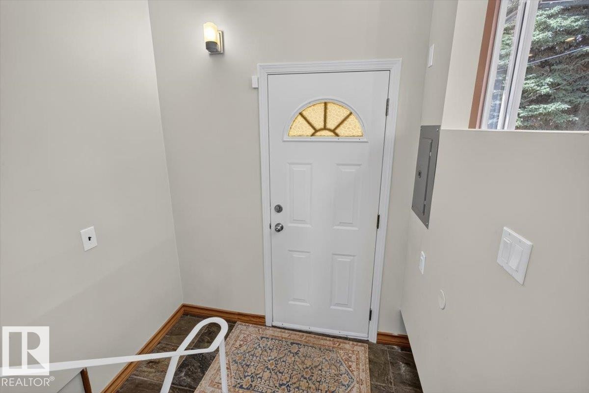 Entryway featuring a white door with a decorative transom window and brushed nickel hardware - 10736 48 Street Nw, Edmonton, AB - Indoor Photo Showing Other Room