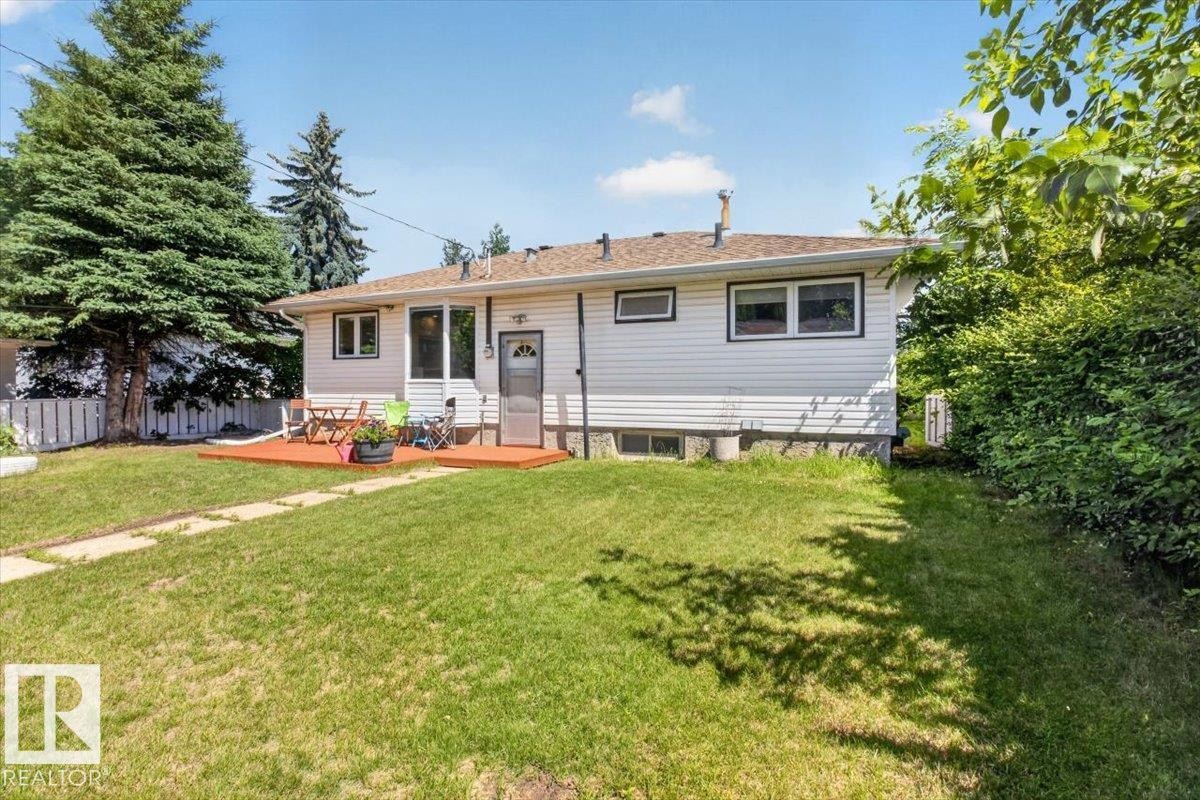 Expansive backyard featuring a manicured lawn, established landscaping, and a wooden deck - 10736 48 Street Nw, Edmonton, AB - Outdoor
