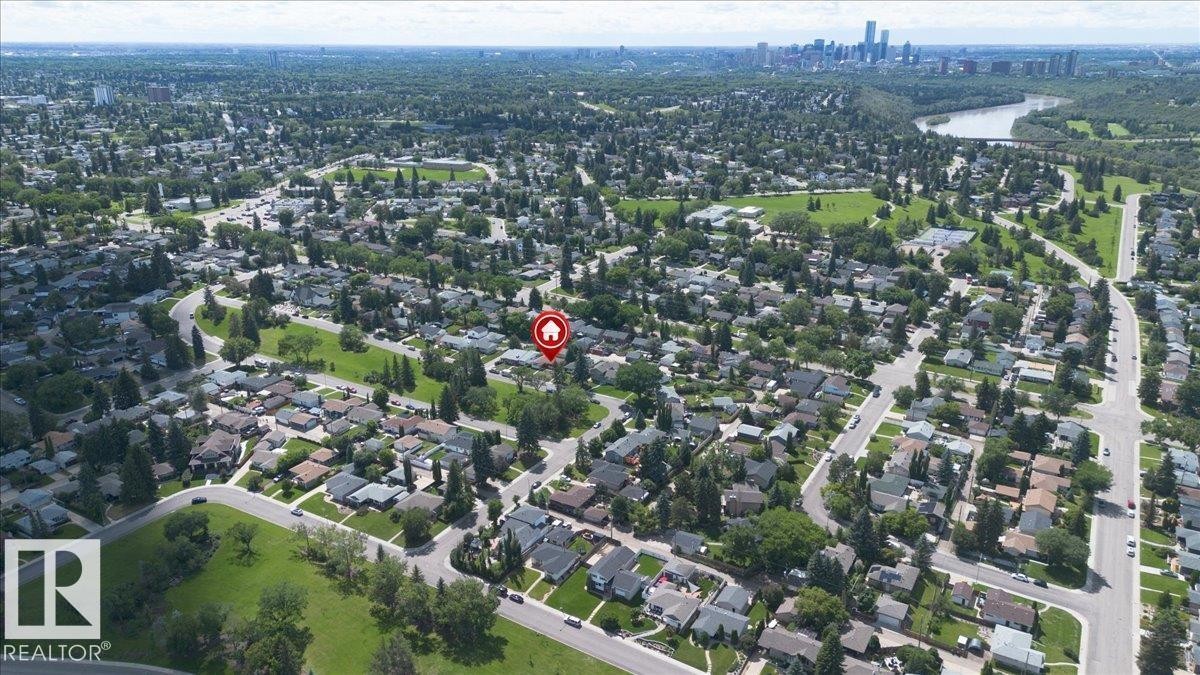 Aerial perspective showcasing a residential neighborhood with a prominent cityscape and river in the background - 10736 48 Street Nw, Edmonton, AB - Outdoor With View