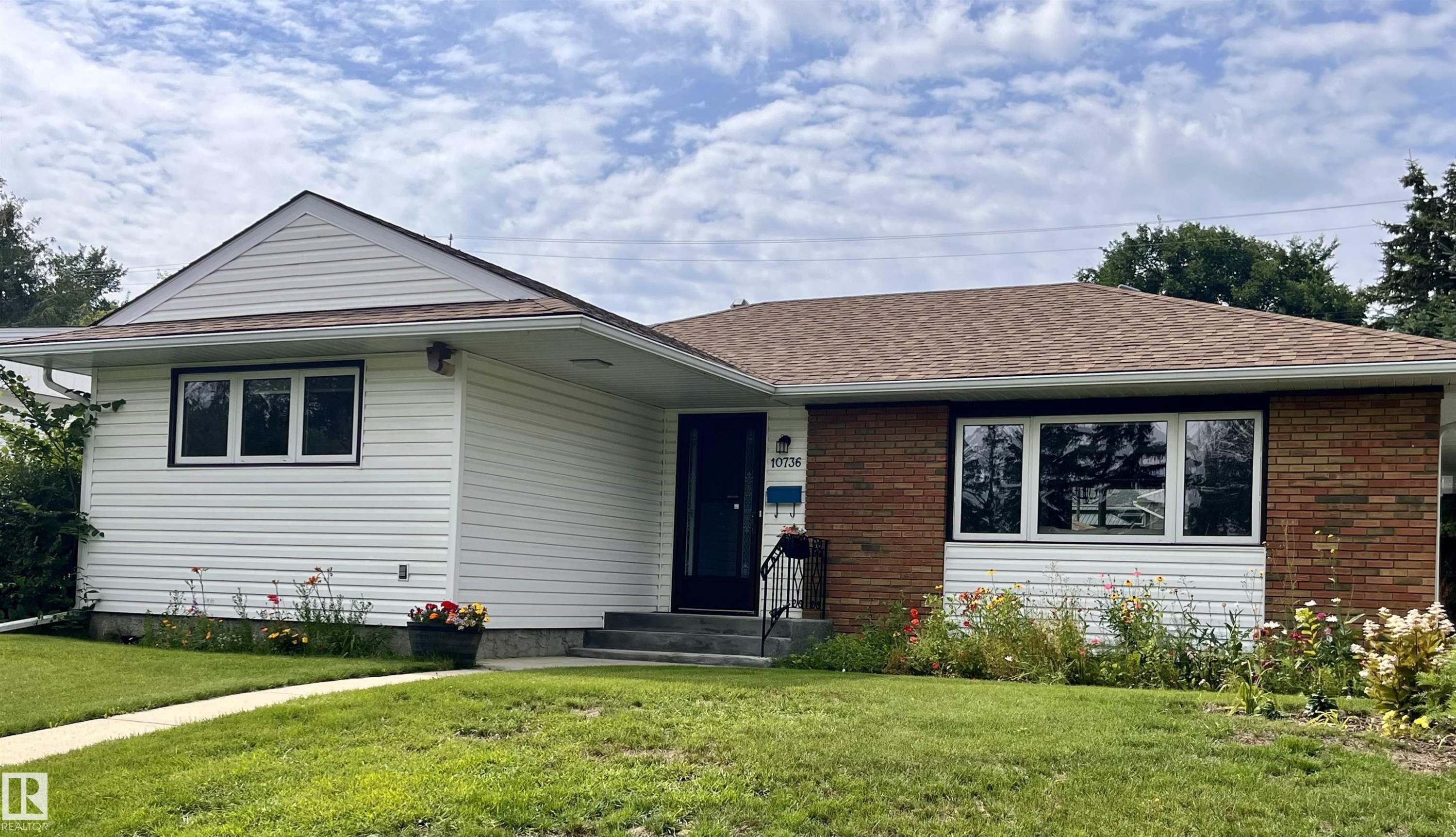 Brick and siding exterior with a shingle roof and a central entrance - 10736 48 Street Nw, Edmonton, AB - Outdoor