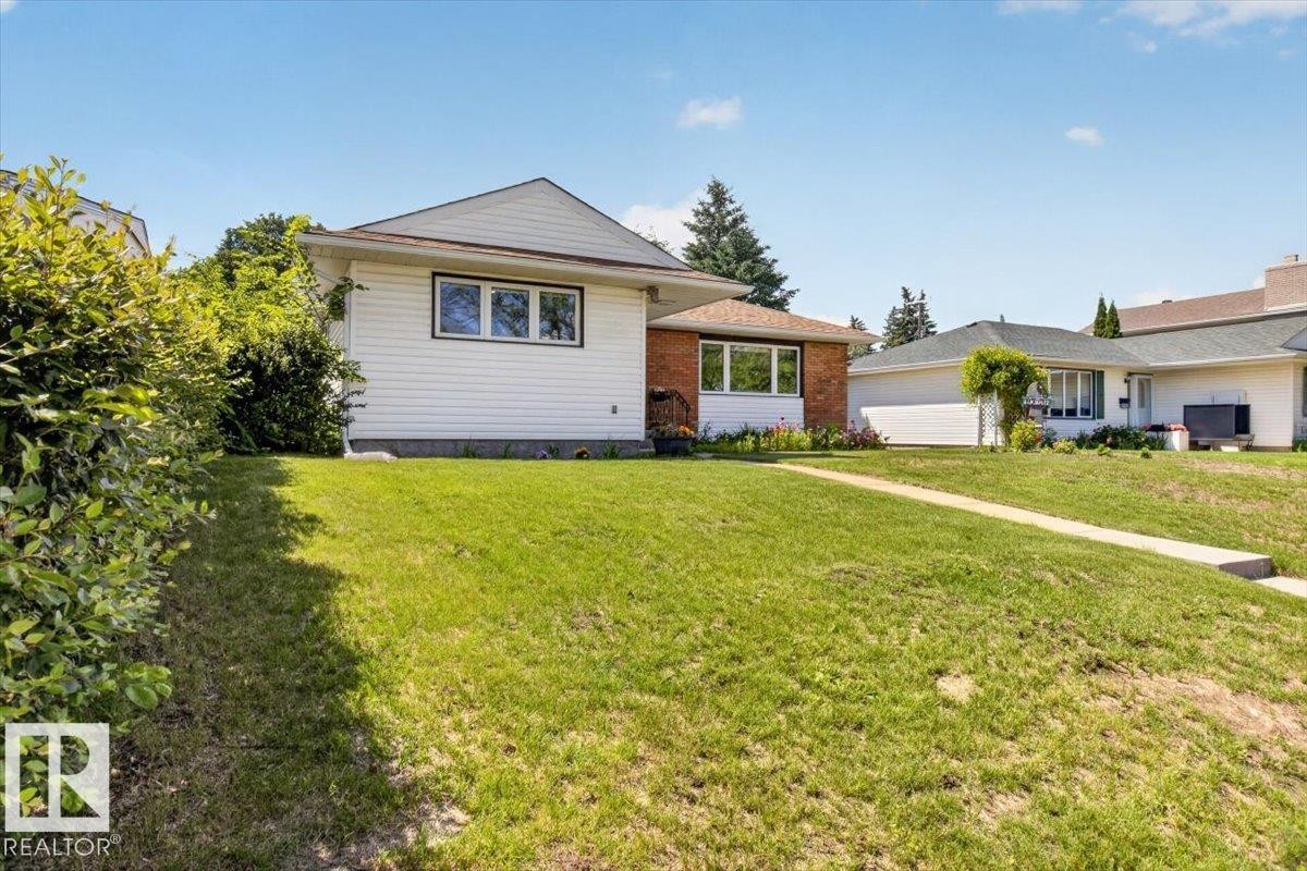 Exterior featuring white siding and brick accents with a gabled roofline - 10736 48 Street Nw, Edmonton, AB - Outdoor