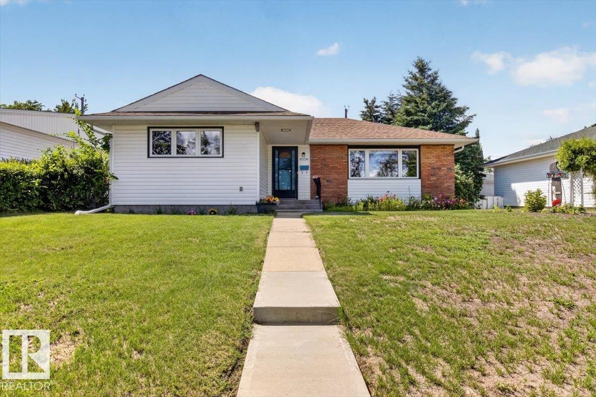 Exterior featuring a blend of white siding and brick facade, a front walkway, and green landscaping - 10736 48 Street Nw, Edmonton, AB - Outdoor