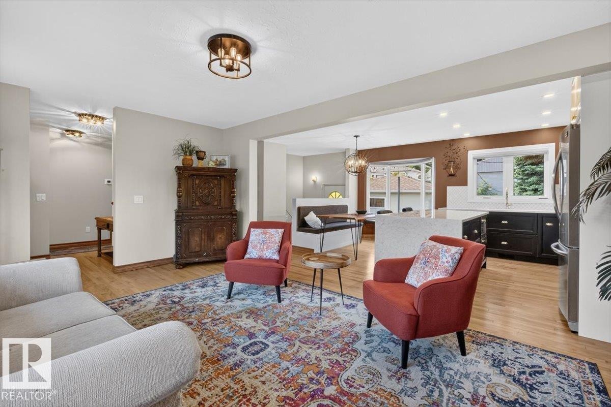 Open-concept living space featuring wood-finish flooring, recessed lighting, and a modern kitchen - 10736 48 Street Nw, Edmonton, AB - Indoor Photo Showing Living Room