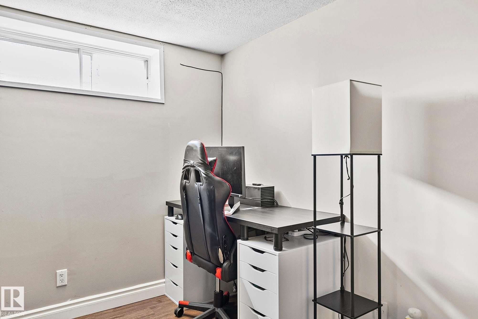 Recessed window offering natural light, smooth ceiling finish, light-toned wall paint, white baseboards, and wood-finish flooring - 17059 98 Street, Edmonton, AB - Indoor