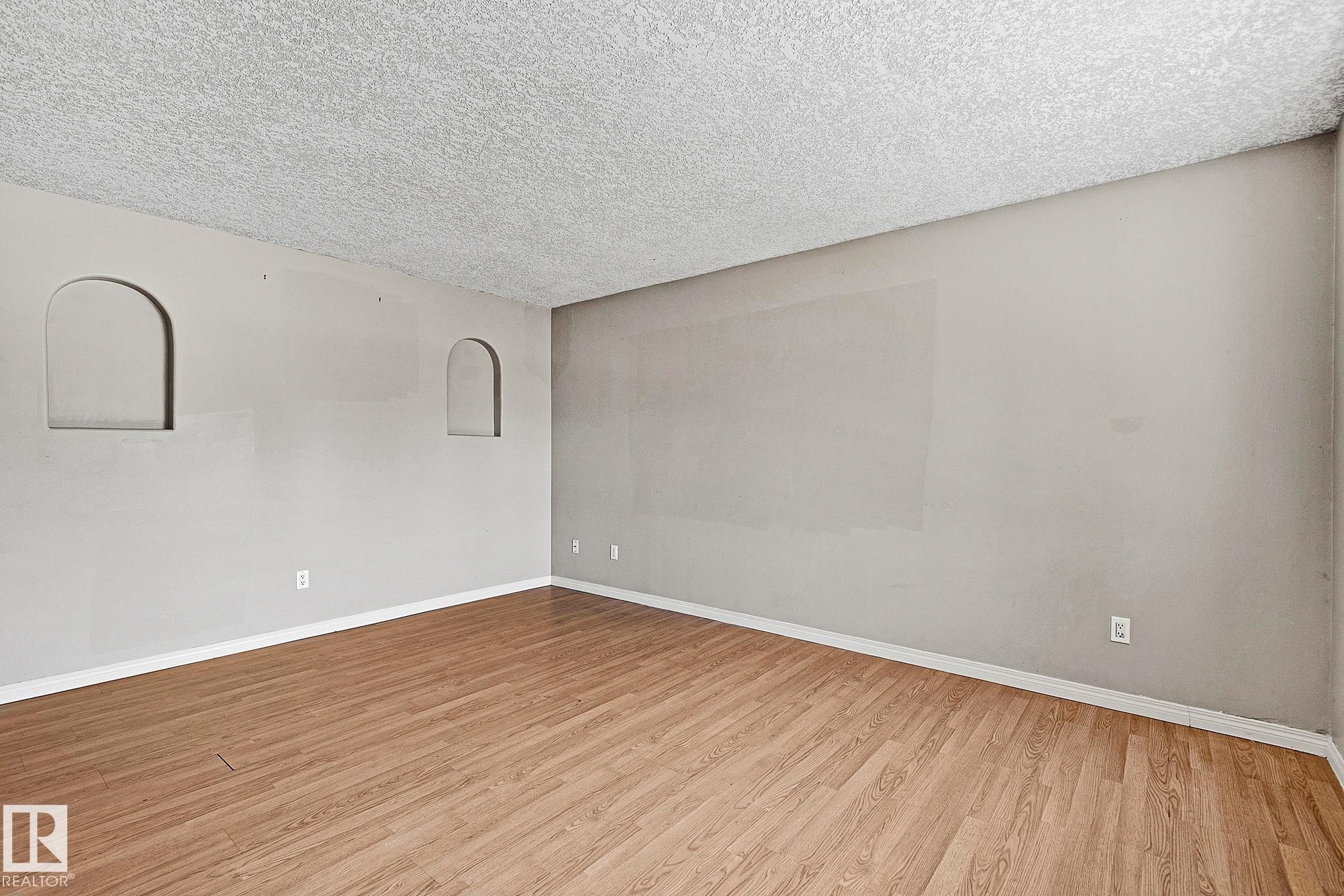 Spacious room with wood-finish flooring and neutral wall tones - 17059 98 Street, Edmonton, AB - Indoor Photo Showing Other Room