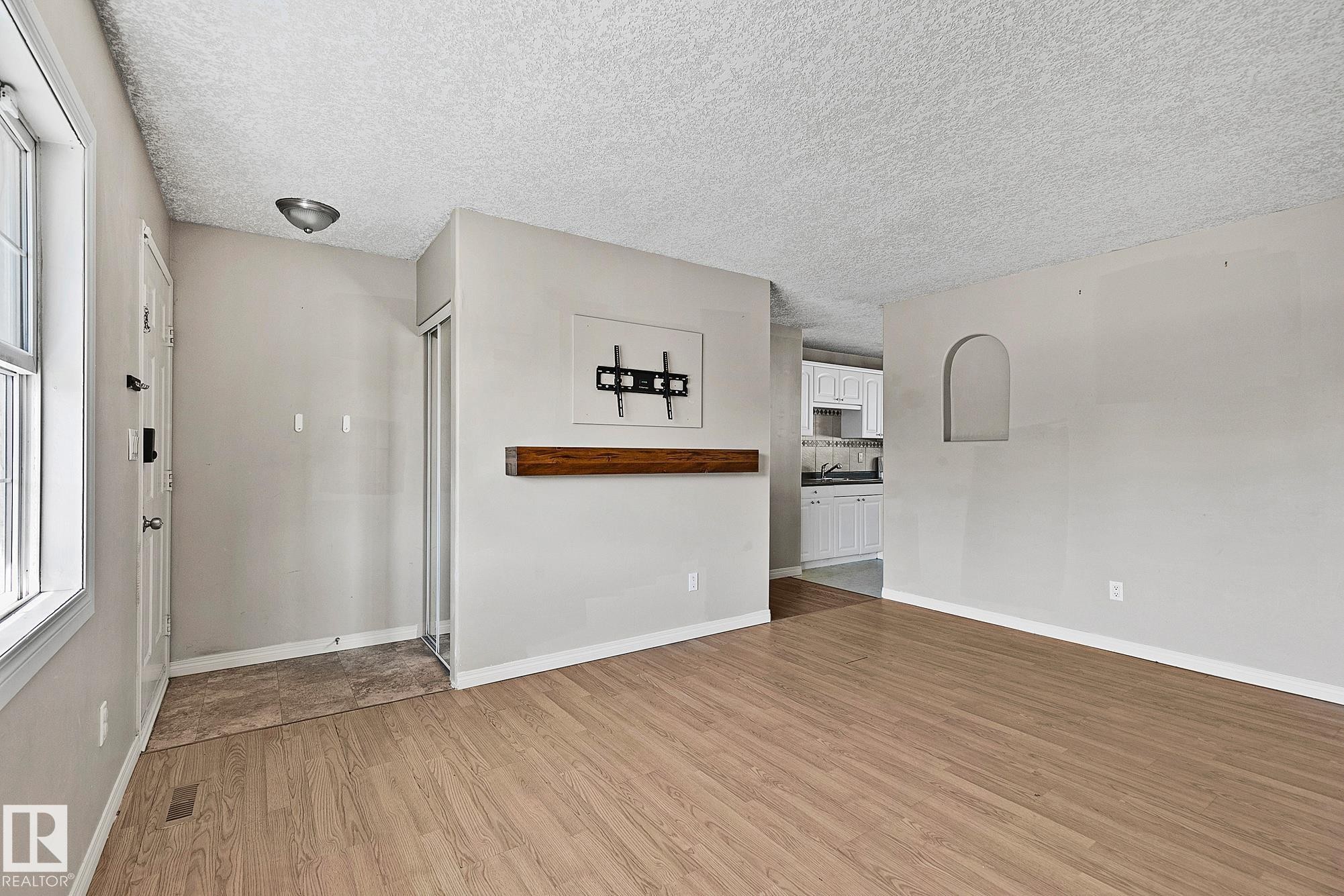 Light wood-finish flooring extends through the main living area - 17059 98 Street, Edmonton, AB - Indoor Photo Showing Other Room
