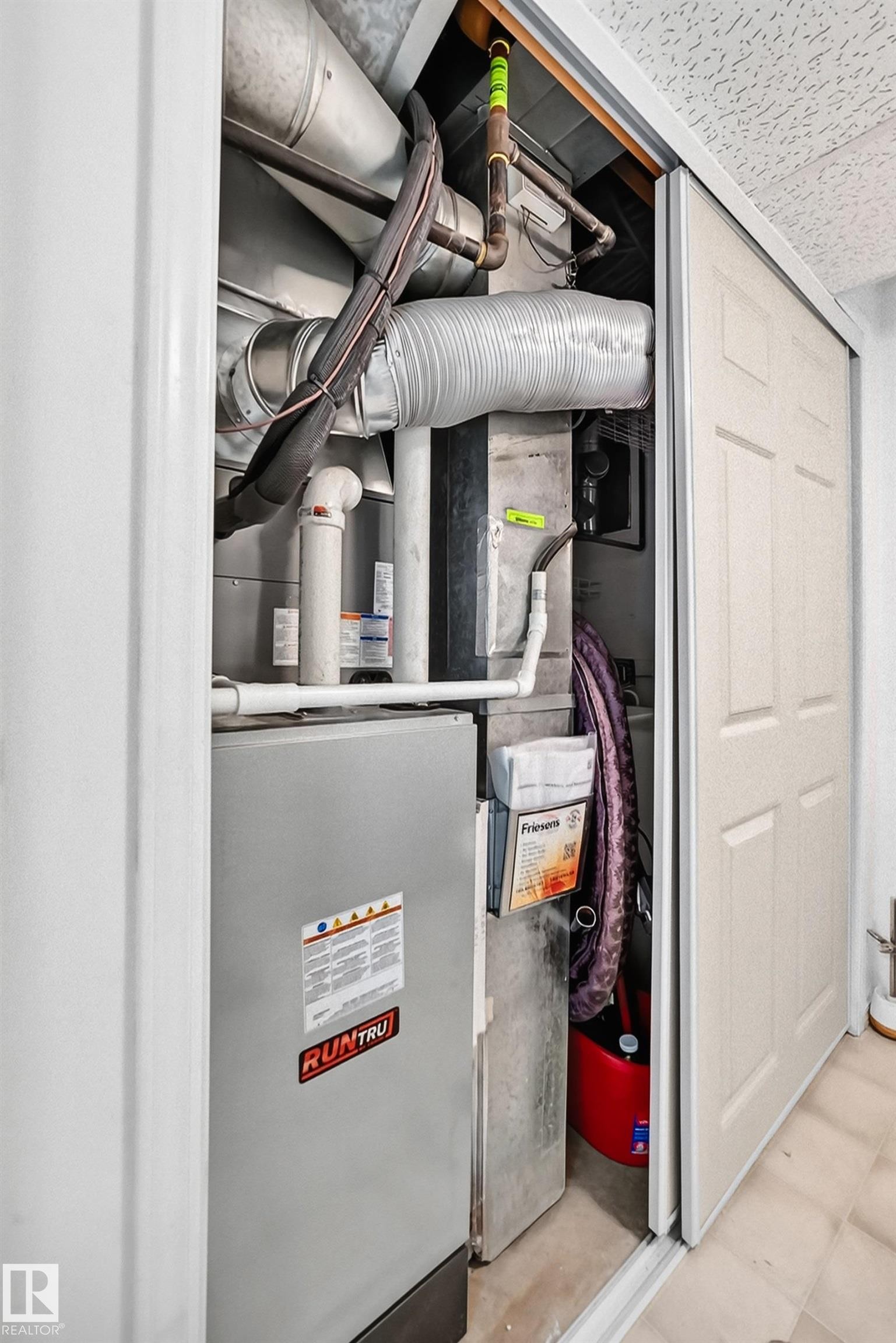 Utility closet housing a RunTru furnace unit, extensive ductwork, and exposed piping - #51 9630 176 St Nw, Edmonton, AB - Indoor Photo Showing Basement