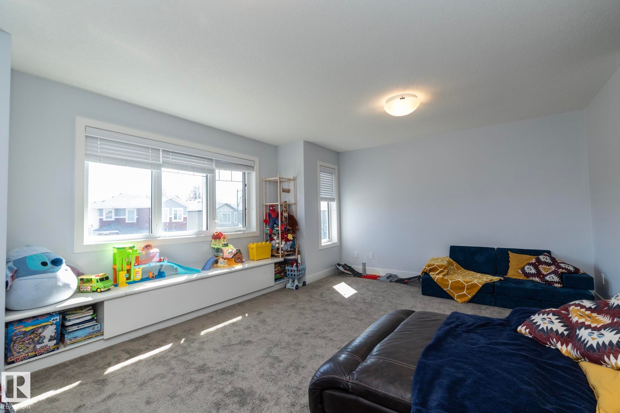 Spacious room featuring a wide window with a built-in storage bench, a secondary window, and recessed lighting - 2016 Redtail Common, Edmonton, AB