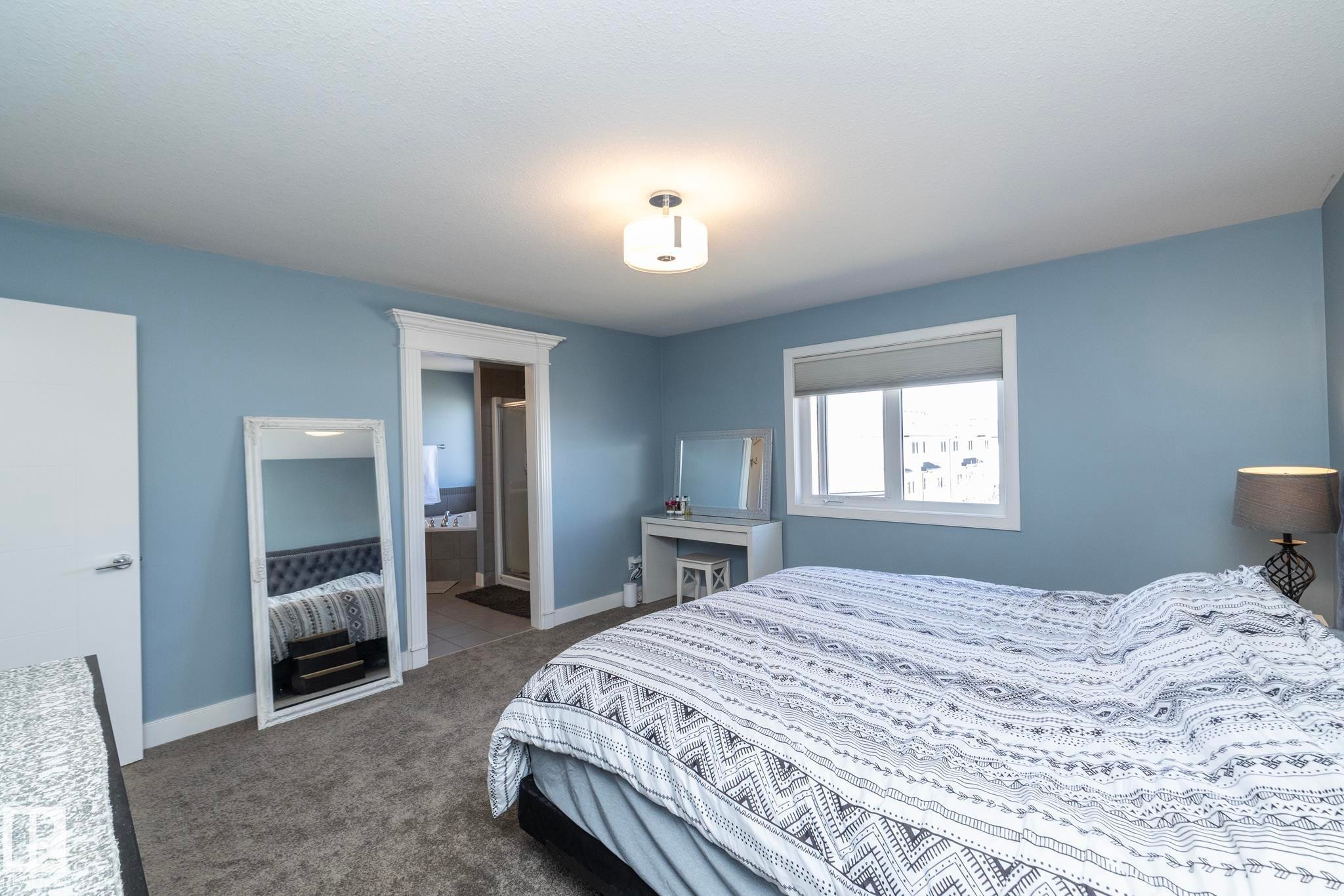 Spacious room featuring light blue walls, gray carpet, and a window with a roller shade - 2016 Redtail Common, Edmonton, AB