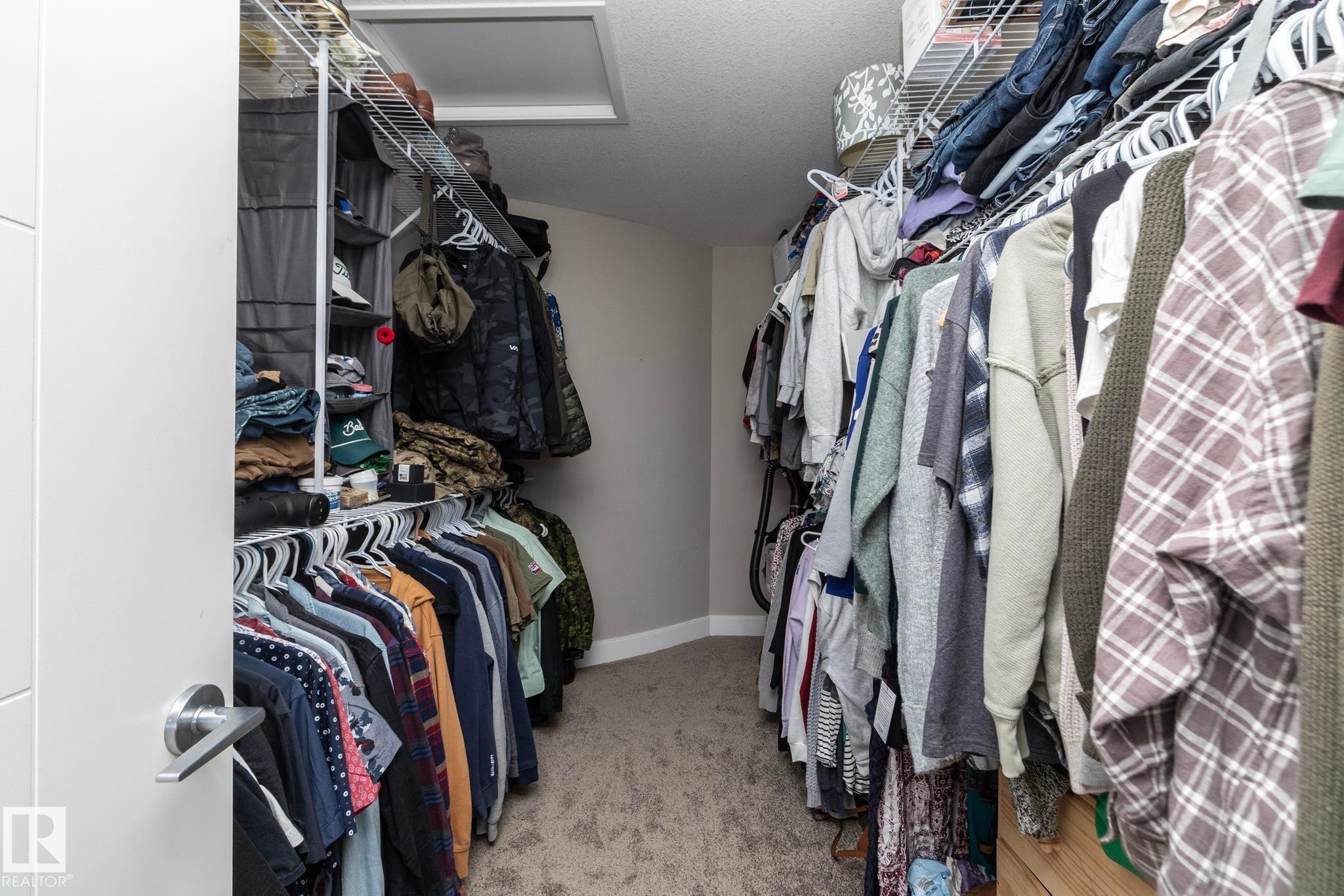 Walk-in closet featuring wire shelving, hanging rods, and carpet flooring - 2016 Redtail Common, Edmonton, AB