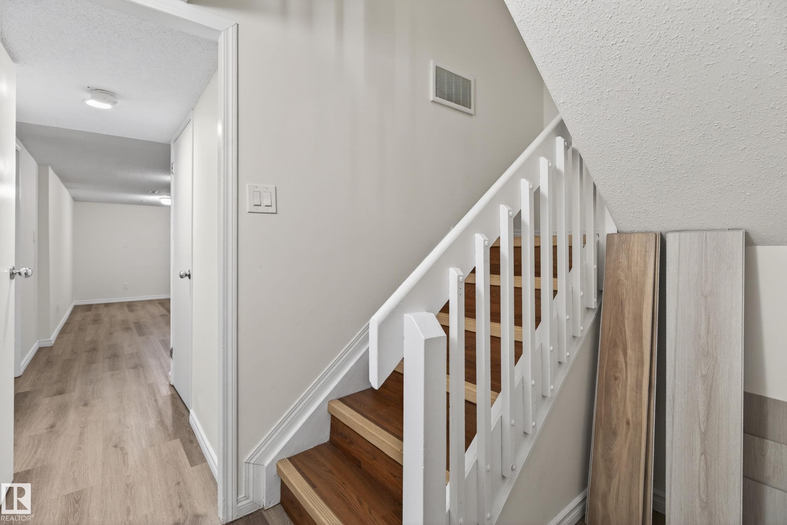 Staircase featuring wood-finish treads and white balusters - 156 Lee Ridge Road, Edmonton, AB - Indoor Photo Showing Other Room