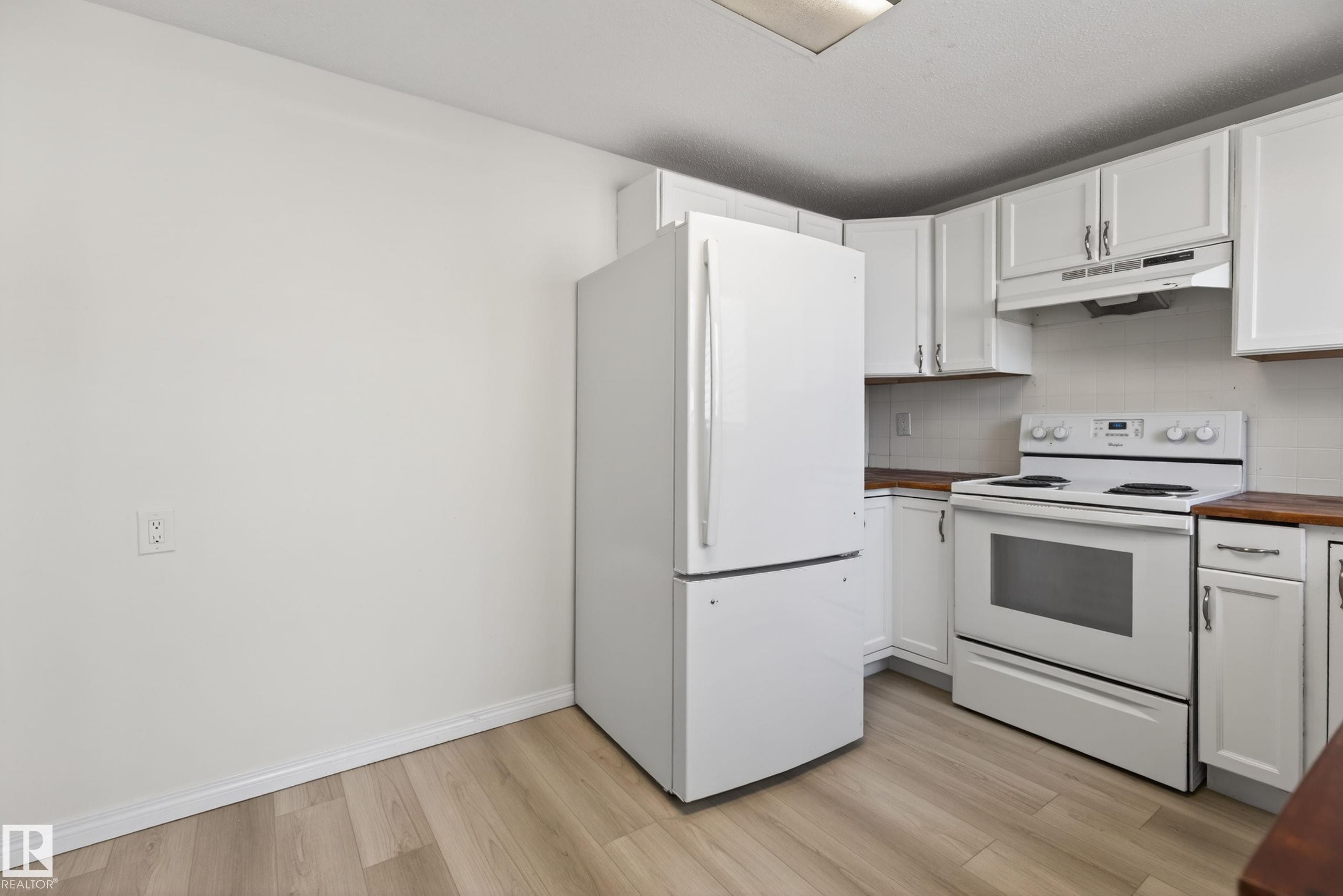 Kitchen featuring white cabinetry, wood-finish countertops, and matching white appliances including a refrigerator and electric range with an overhead vent - 156 Lee Ridge Road, Edmonton, AB - Indoor Photo Showing Kitchen