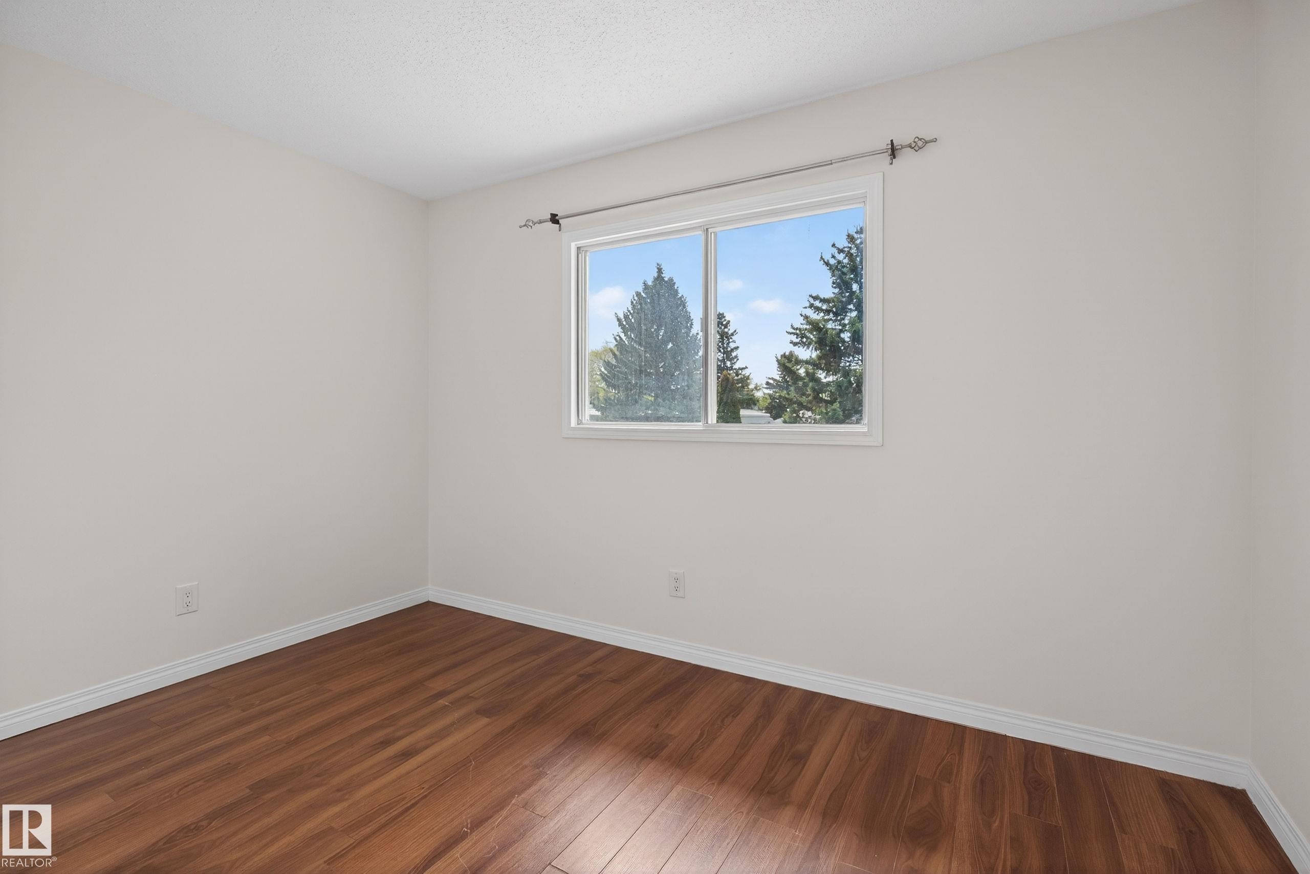 Bright room featuring wood-finish flooring, white baseboards, and a large window with white trim - 156 Lee Ridge Road, Edmonton, AB - Indoor Photo Showing Other Room