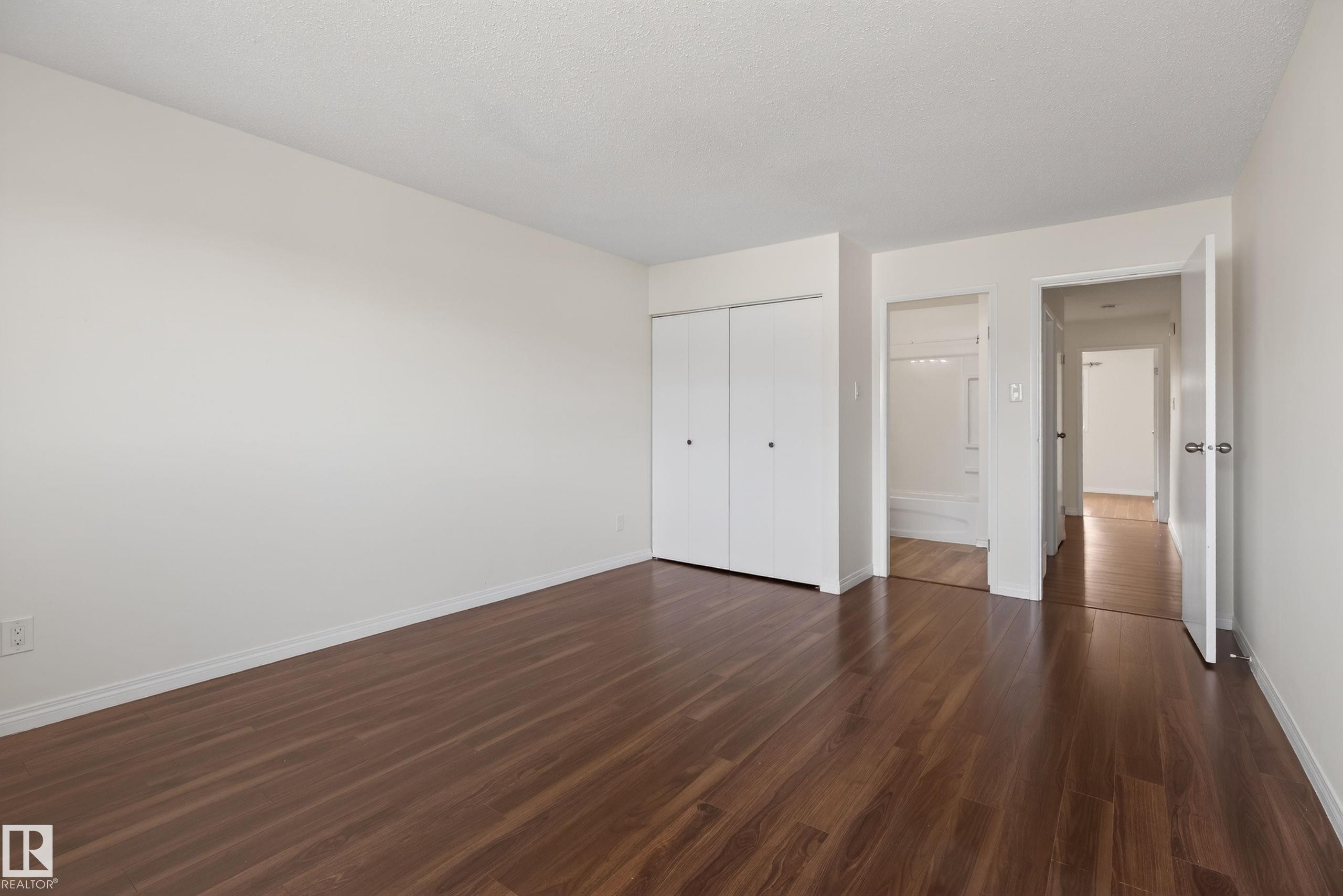 Spacious room featuring wood-finish flooring, white walls, and a ceiling with a textured finish - 156 Lee Ridge Road, Edmonton, AB - Indoor Photo Showing Other Room