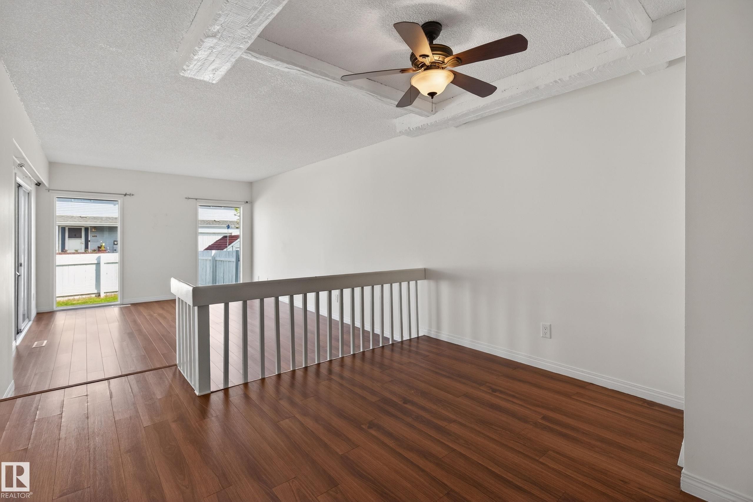 Spacious room featuring wood-finish flooring, white walls, and a ceiling fan with light fixture - 156 Lee Ridge Road, Edmonton, AB - Indoor Photo Showing Other Room