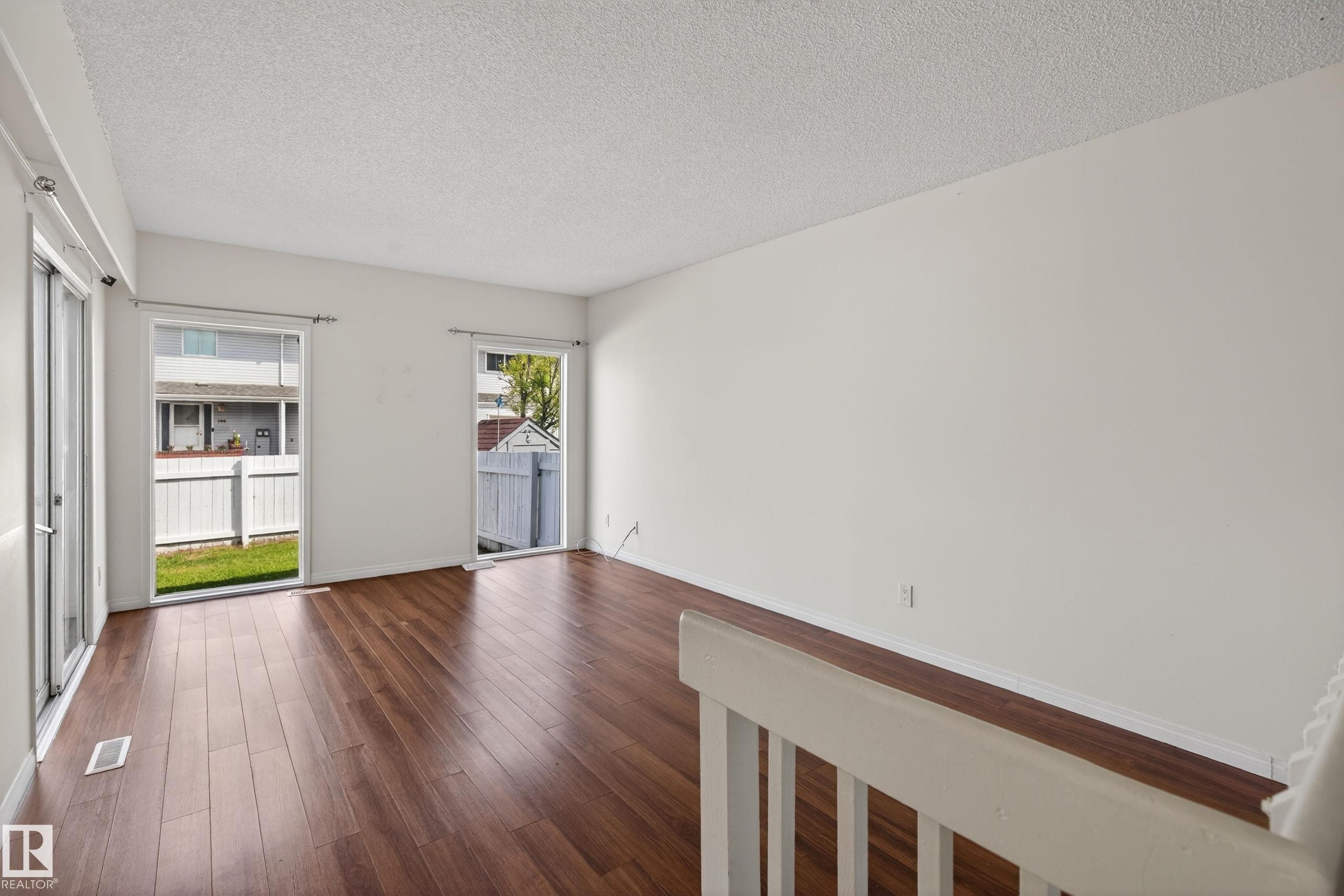 Spacious room featuring wood-finish flooring, white walls, and a textured white ceiling - 156 Lee Ridge Road, Edmonton, AB - Indoor Photo Showing Other Room