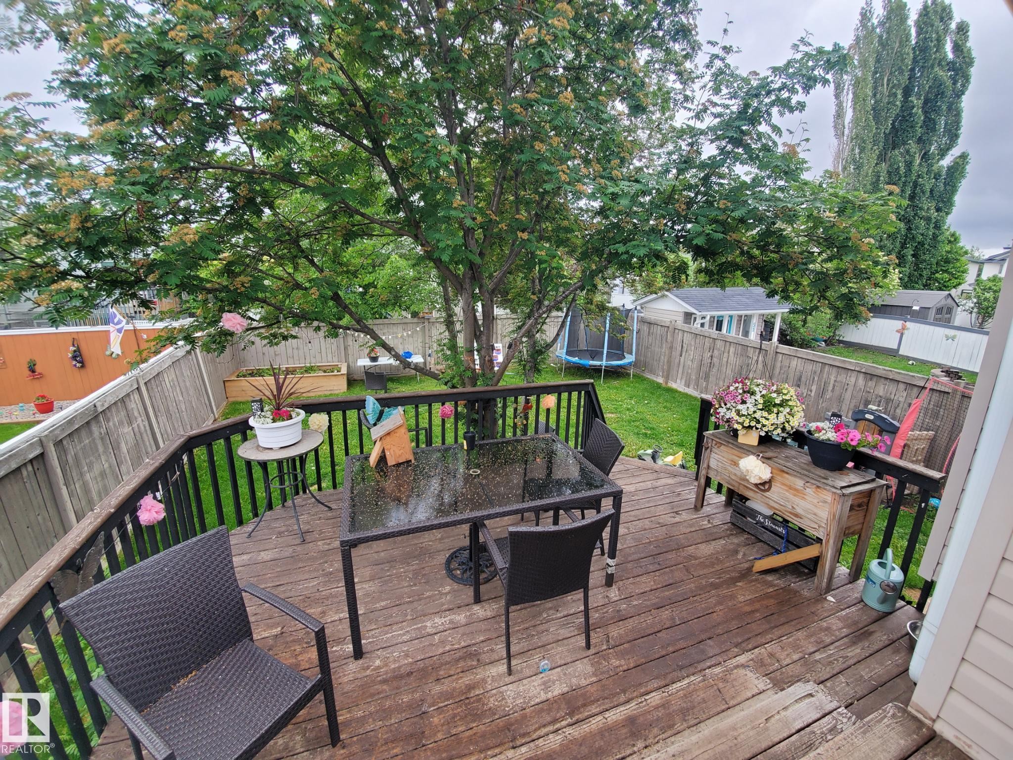 Wood-finish deck with black metal railings - 53 Langley, Spruce Grove, AB
