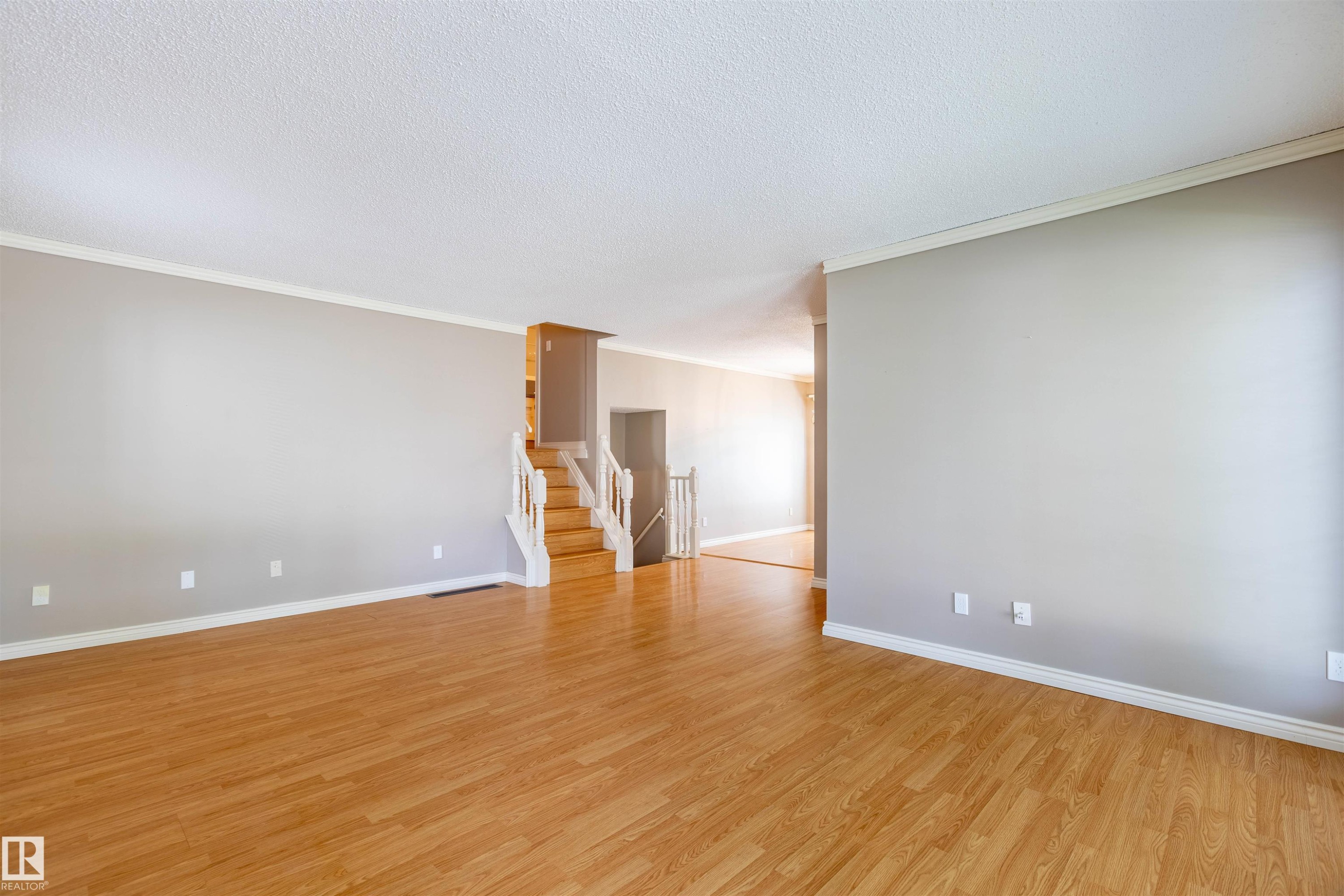 Spacious interior featuring wood-finish flooring and light gray walls - 3 Glenforest Crescent, Stony Plain, AB