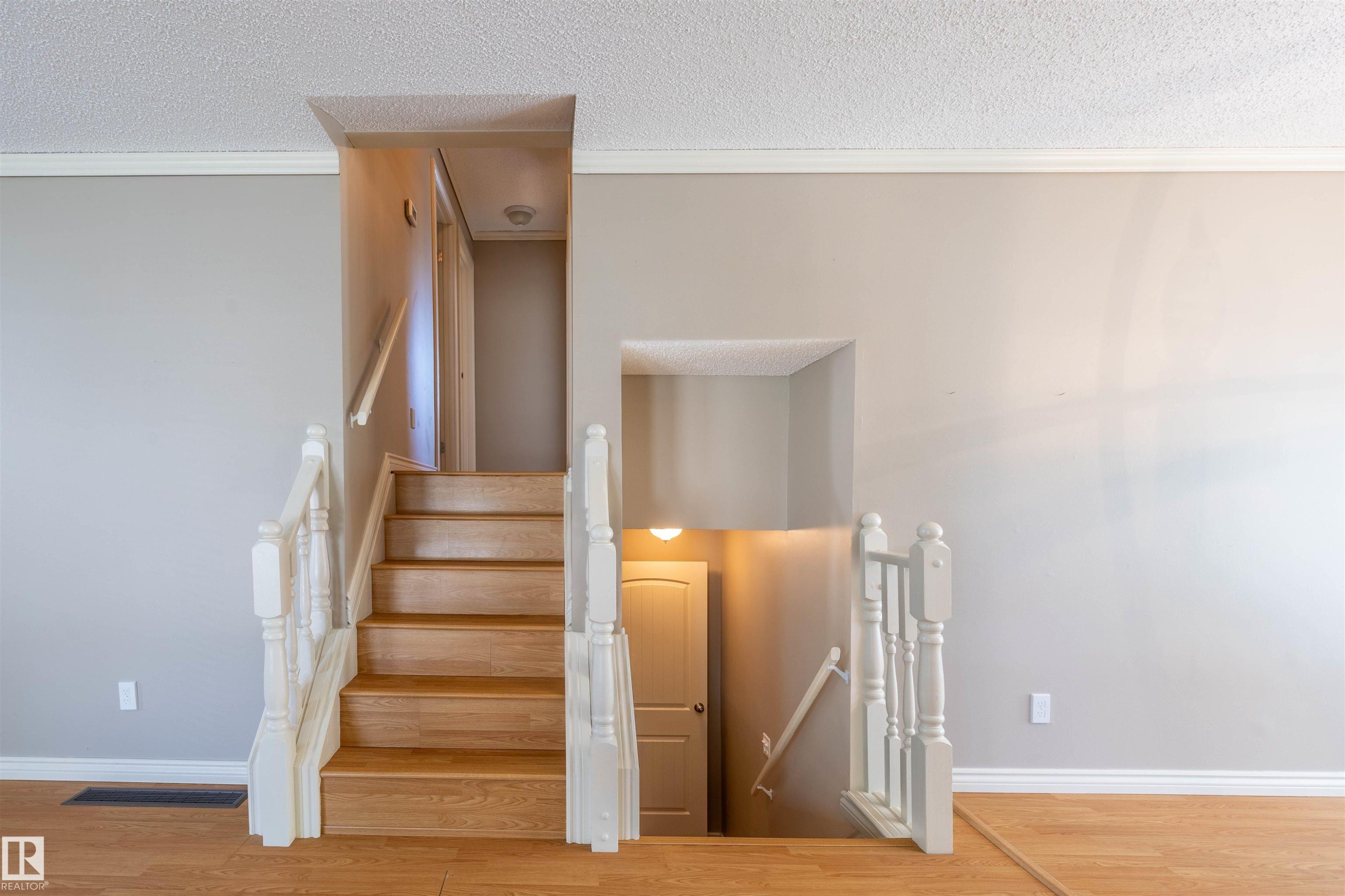 Wood-finish staircase with white balusters and handrails - 3 Glenforest Crescent, Stony Plain, AB