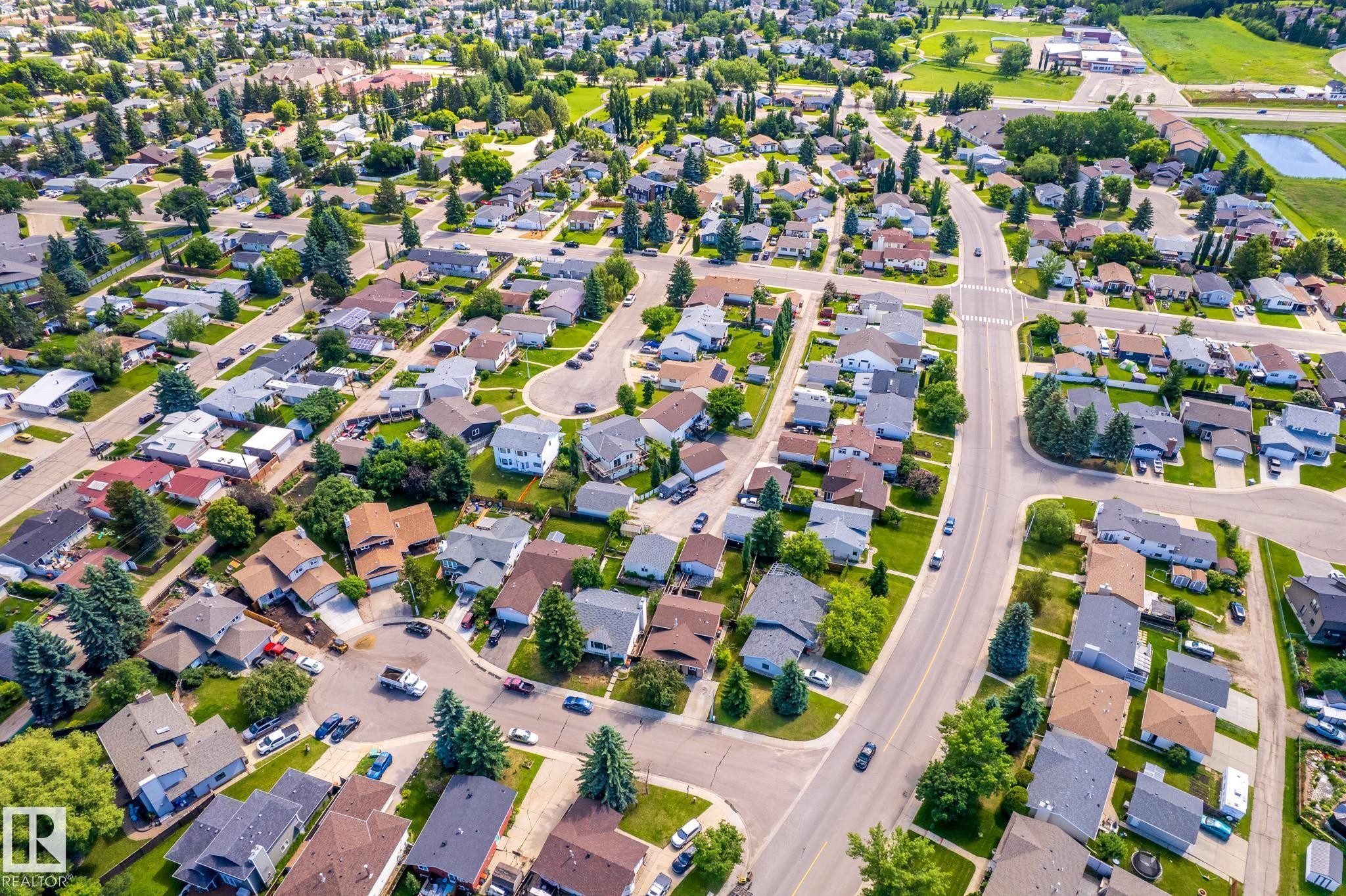 Aerial perspective of a residential neighborhood featuring numerous detached homes with varying rooflines and mature tree coverage - 3 Glenforest Crescent, Stony Plain, AB