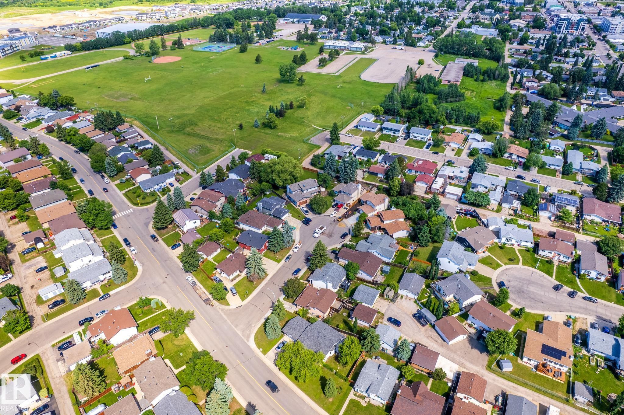 Aerial perspective showcasing a residential area with varied housing styles and mature landscaping - 3 Glenforest Crescent, Stony Plain, AB