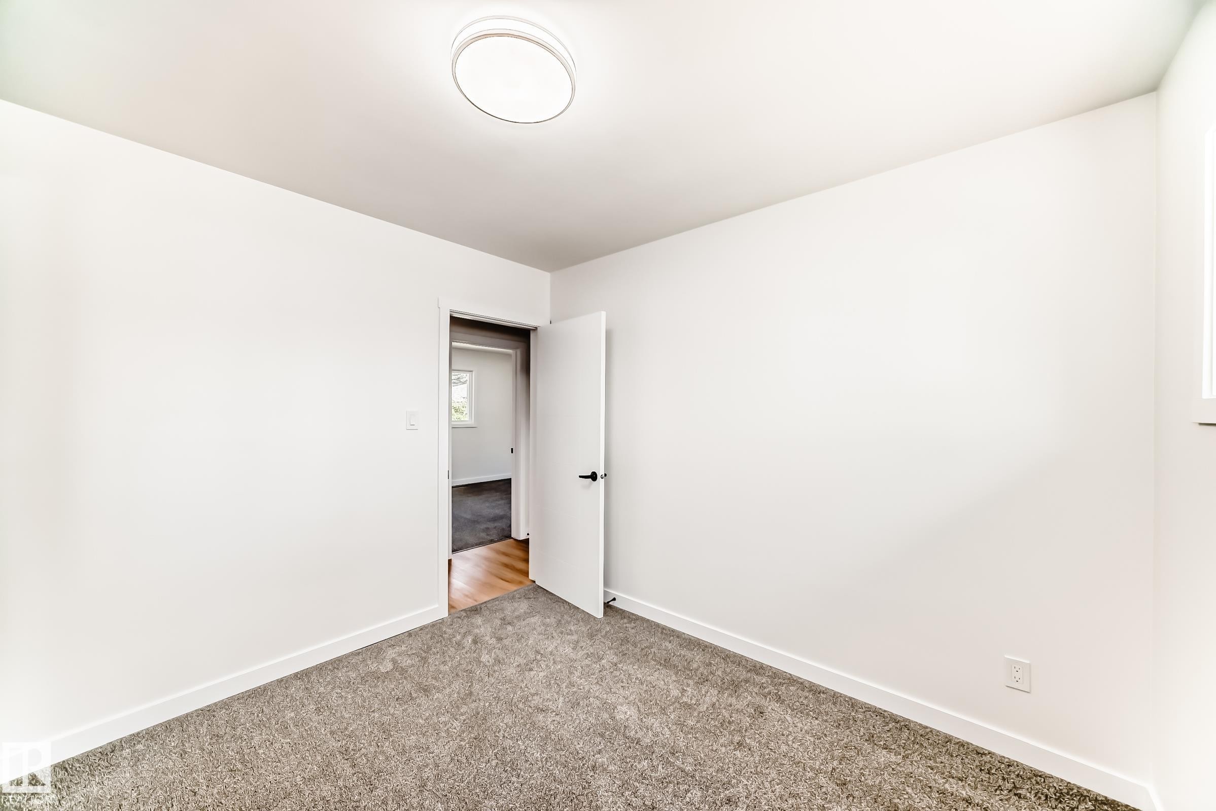 Room featuring light gray carpeting, white walls, and a contemporary ceiling light fixture - 4842 116Ave, Edmonton, AB