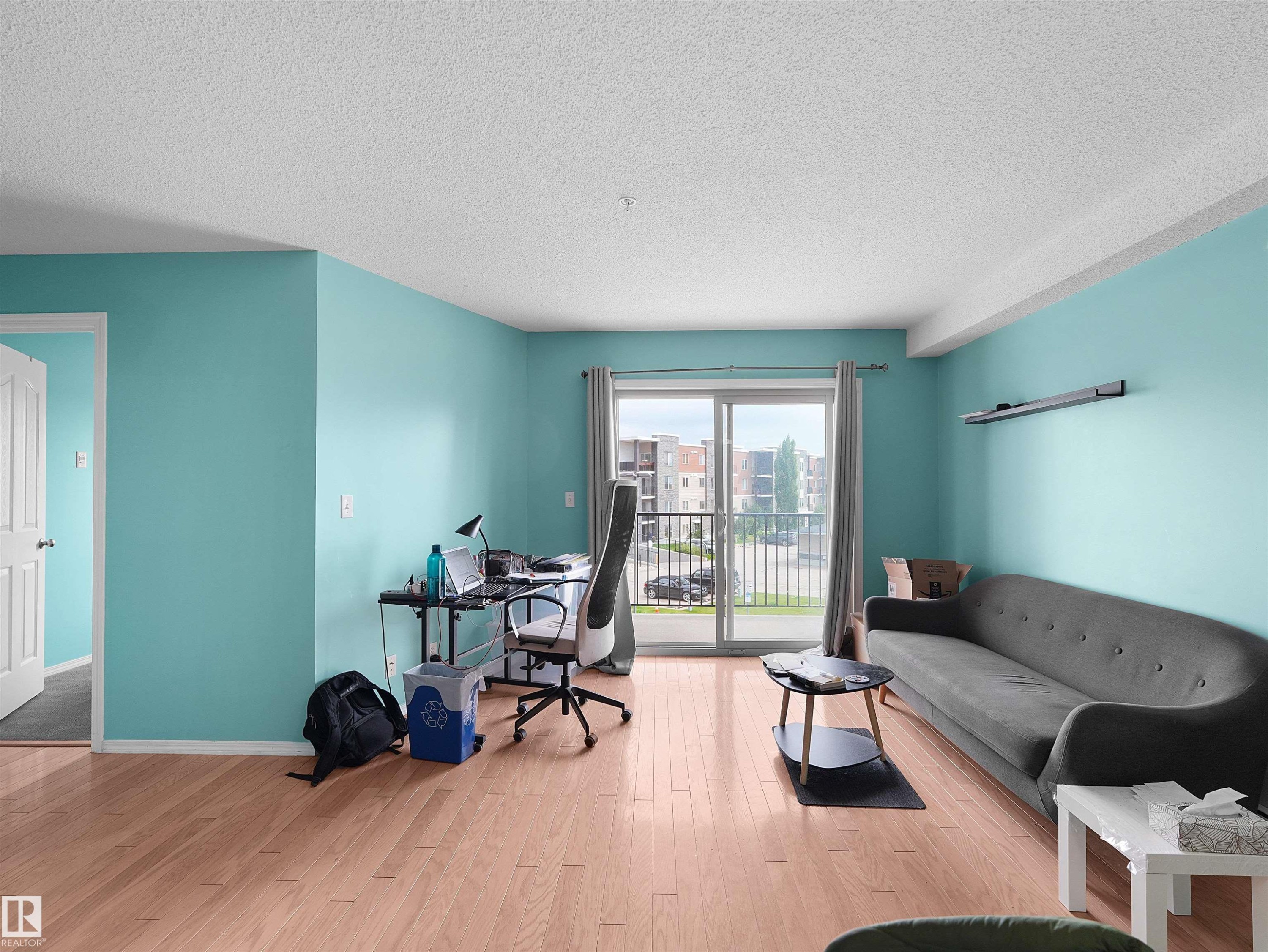 Spacious interior featuring wood-finish flooring, light blue walls, and a white ceiling - #313 11820 22 Av Sw, Edmonton, AB - Indoor