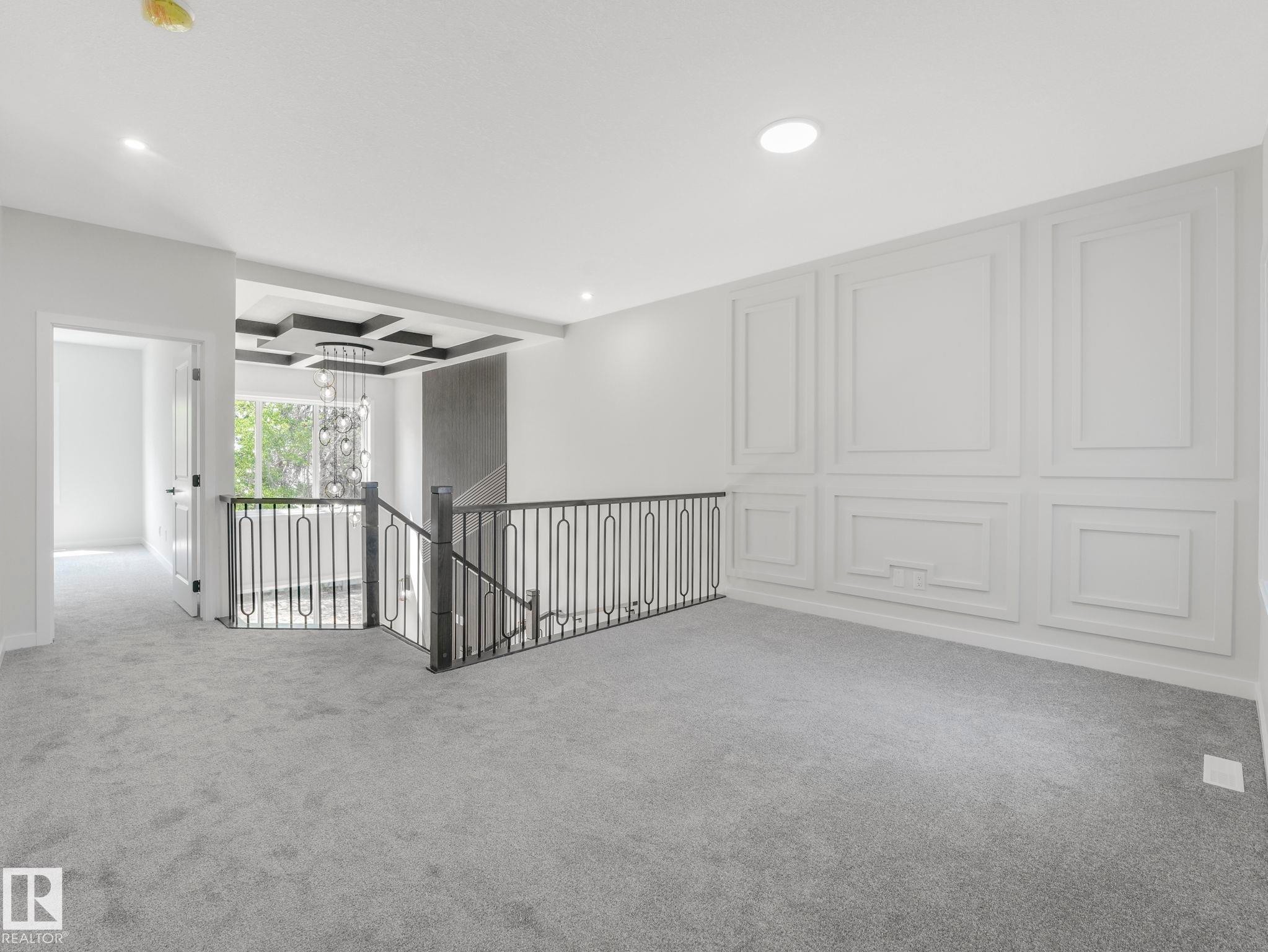 Upper-level landing featuring light gray carpeting, a decorative paneled accent wall, and recessed lighting - 1717 Crossbill Loop, Edmonton, AB - Indoor Photo Showing Other Room