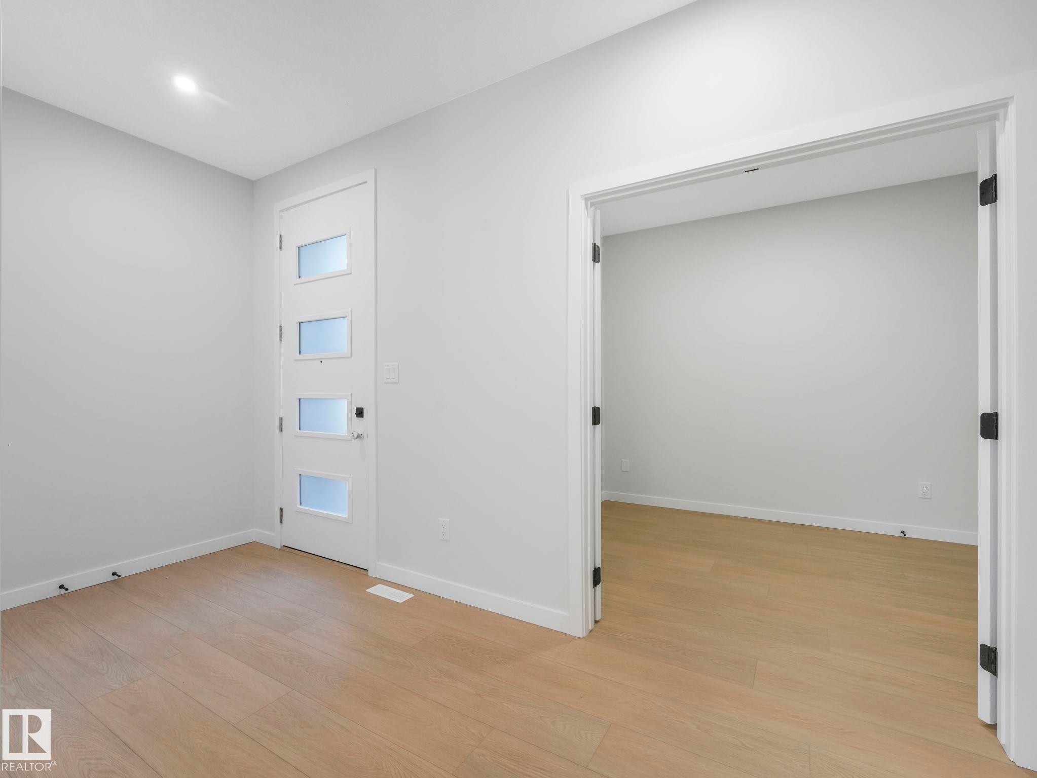 Contemporary entry area featuring a white door with frosted glass panels and sleek black hardware - 1717 Crossbill Loop, Edmonton, AB - Indoor Photo Showing Other Room