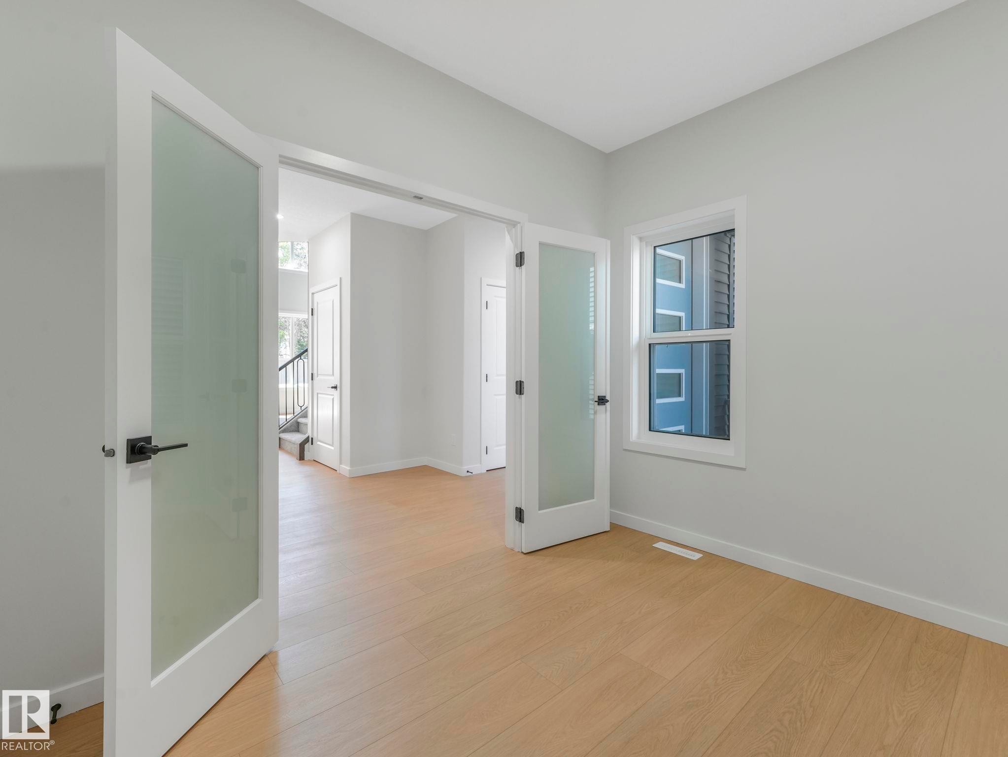 Room featuring light wood-finish flooring, a white window frame, and neutral wall paint - 1717 Crossbill Loop, Edmonton, AB - Indoor Photo Showing Other Room