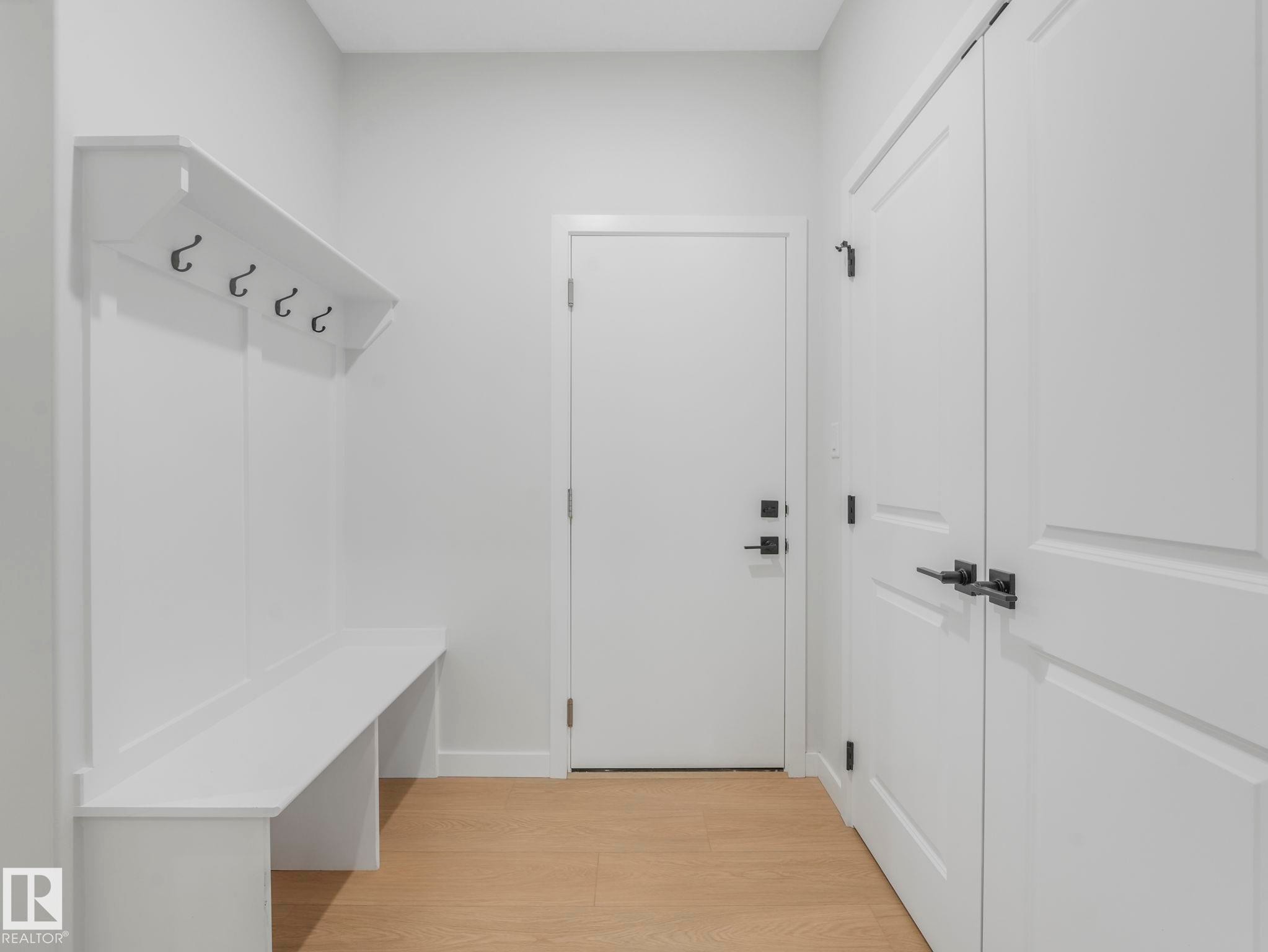 Built-in white storage bench with upper shelf and coat hooks - 1717 Crossbill Loop, Edmonton, AB - Indoor Photo Showing Other Room