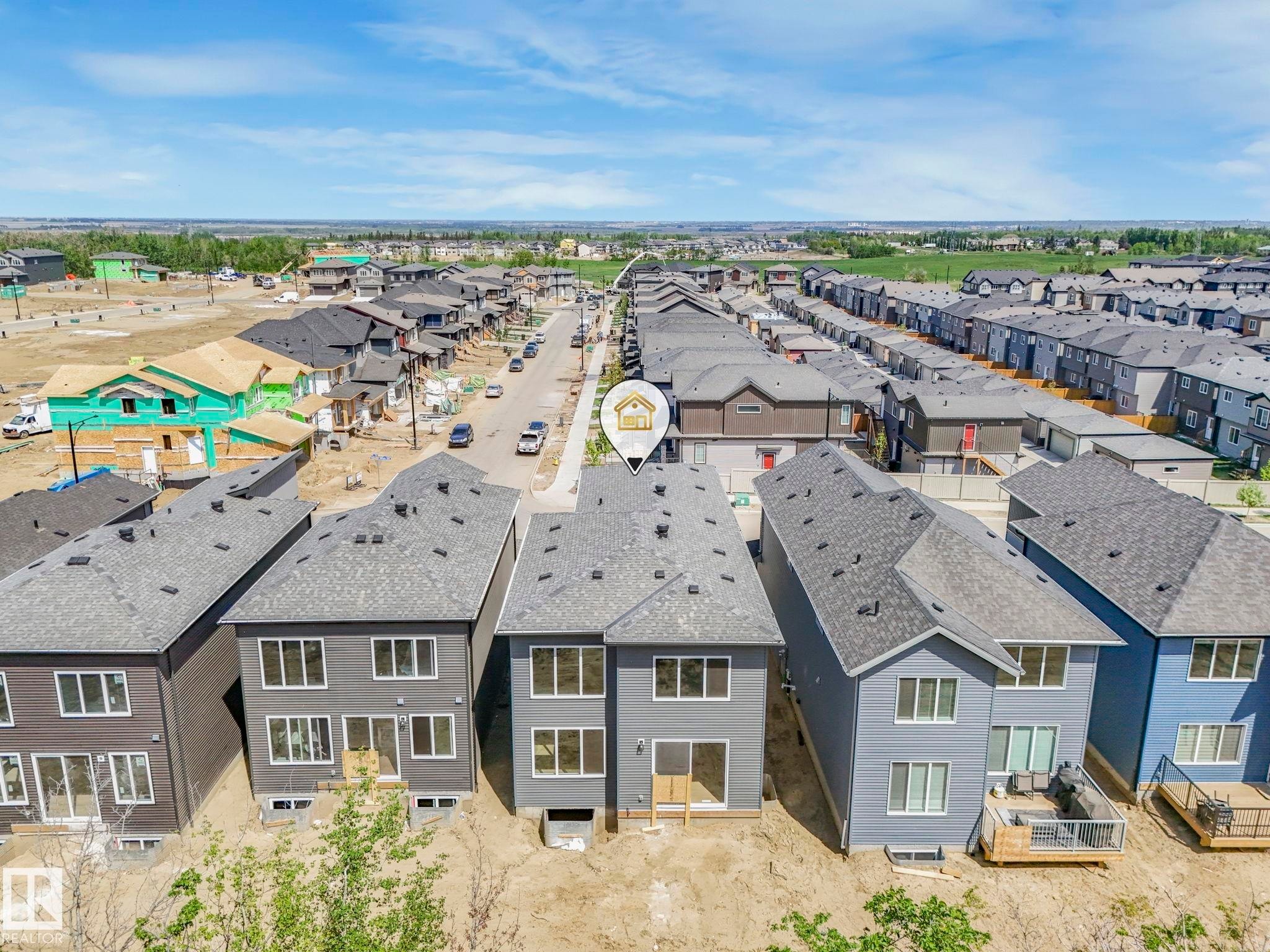 Newly constructed residence featuring a gray exterior, multiple large windows, and a sliding glass door - 1717 Crossbill Loop, Edmonton, AB - Outdoor
