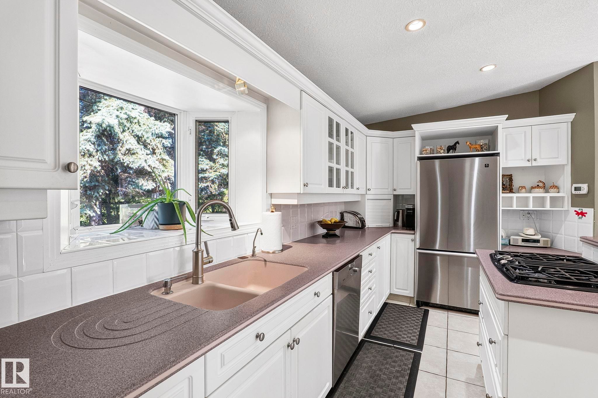 Kitchen featuring white cabinetry, a built-in stainless steel refrigerator, and a gas cooktop - 860 41 Avenue, Edmonton, AB