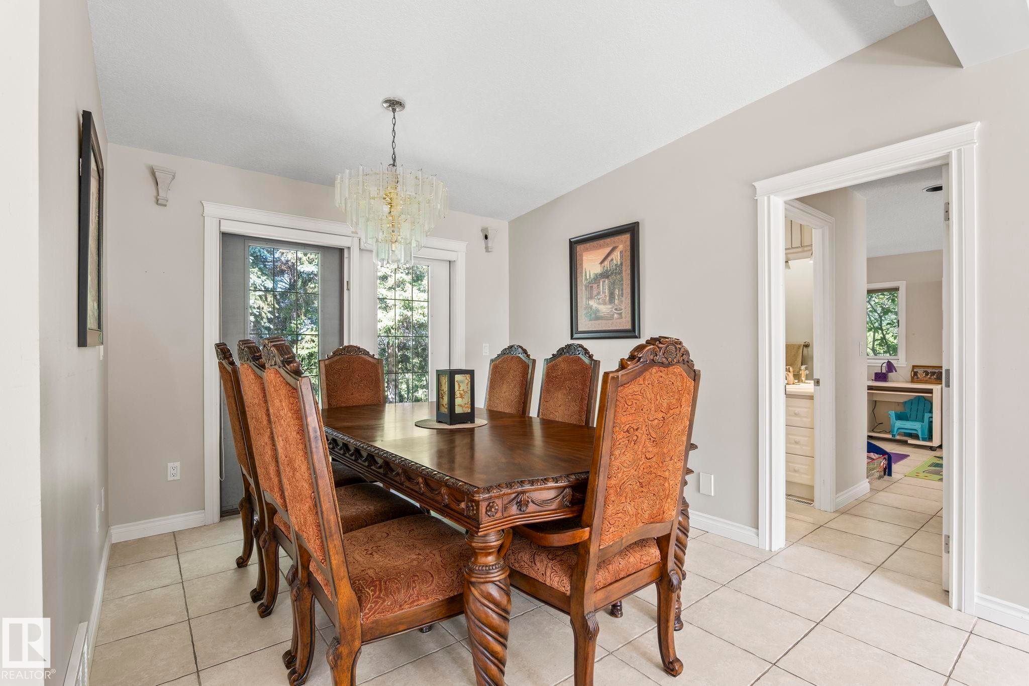 Dining area with tile flooring and a prominent chandelier - 860 41 Avenue, Edmonton, AB