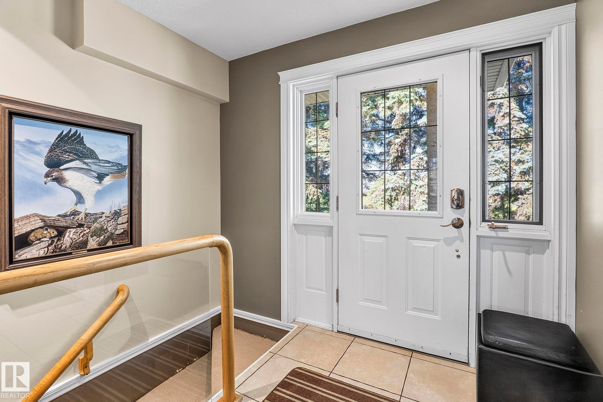 Entryway featuring a white paneled door with decorative glass inserts, flanked by matching sidelight windows and a transom window - 860 41 Avenue, Edmonton, AB