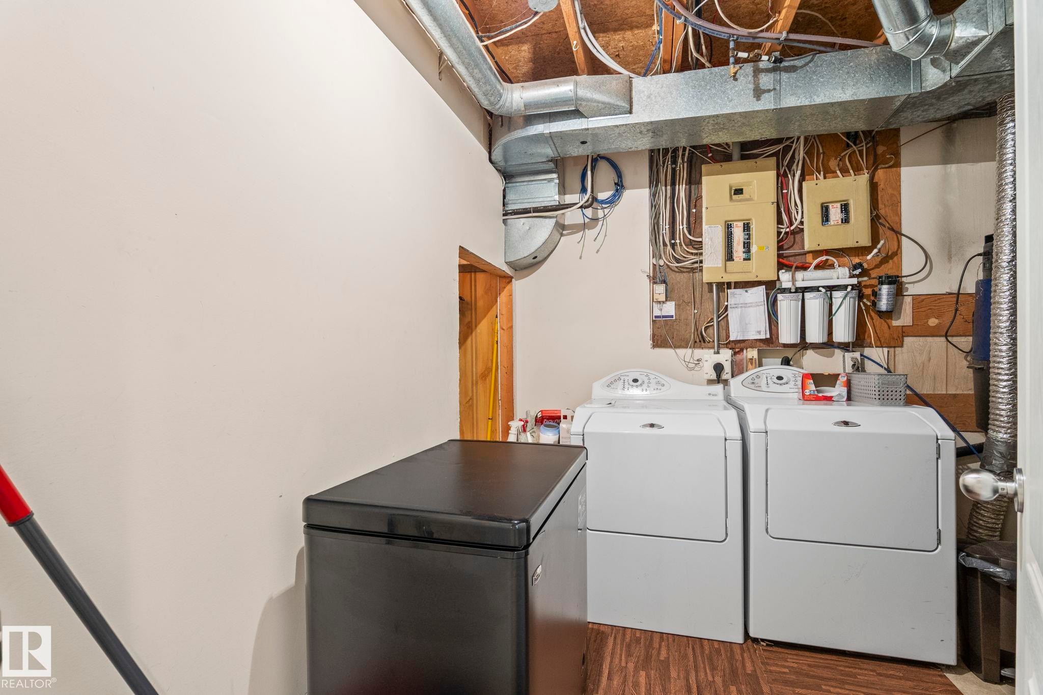 Utility space featuring exposed ductwork, exposed electrical conduits, and a wood-finish floor - 860 41 Avenue, Edmonton, AB