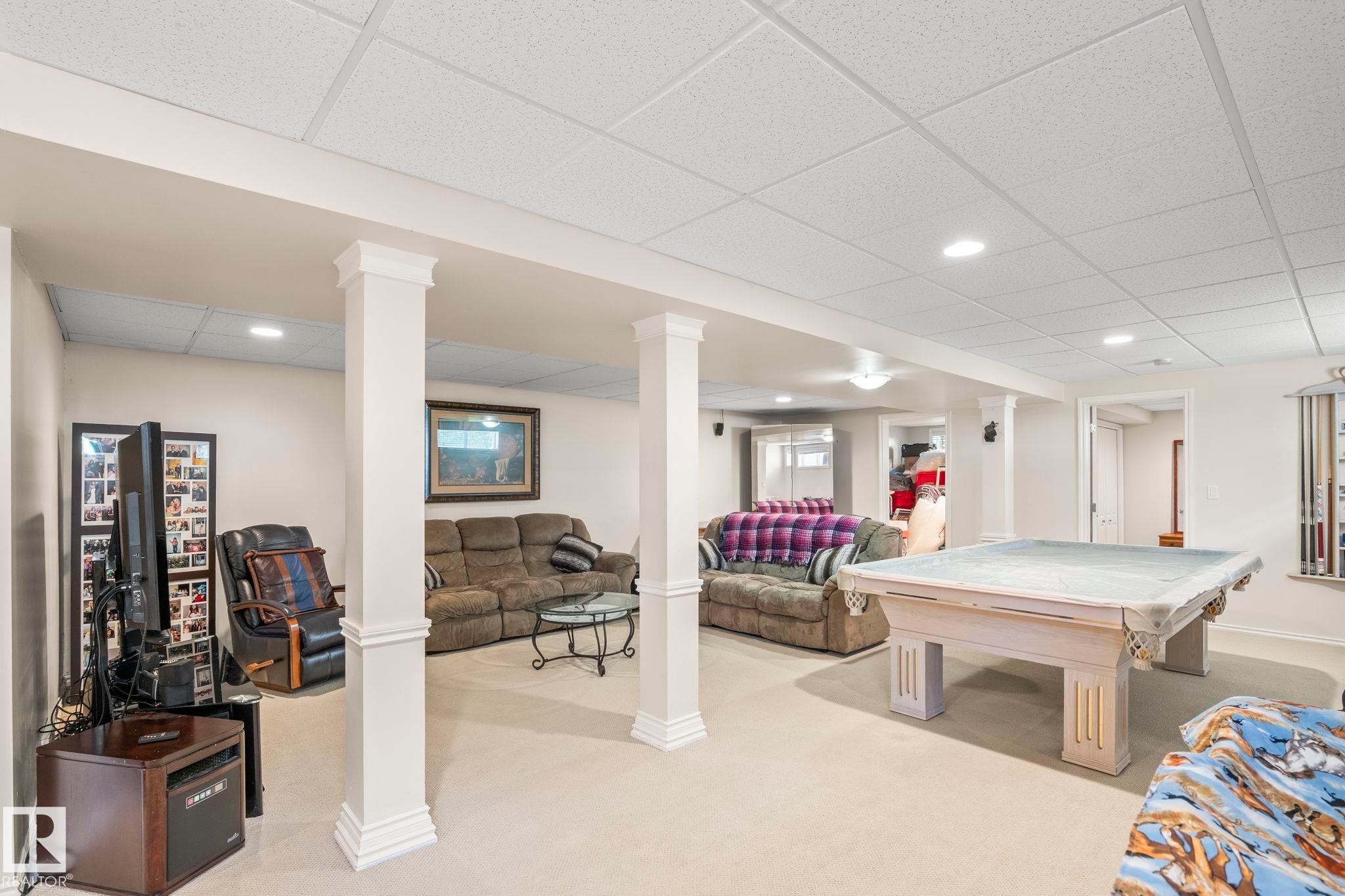 Spacious lower-level entertainment area featuring recessed lighting, a drop-panel ceiling, and light-toned carpeting - 860 41 Avenue, Edmonton, AB