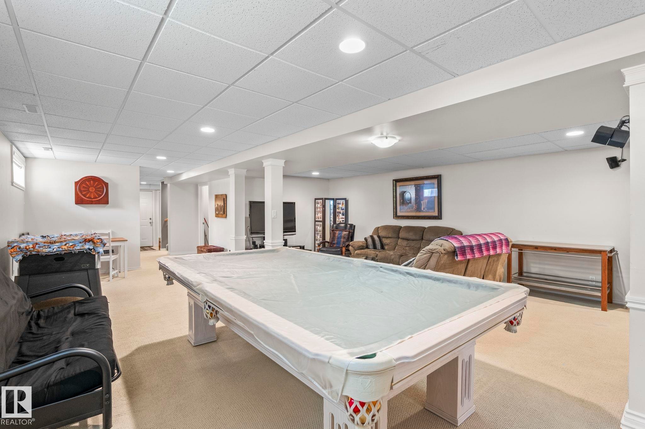 Spacious finished room featuring recessed lighting, carpeted flooring, and structural columns with crown molding accents - 860 41 Avenue, Edmonton, AB