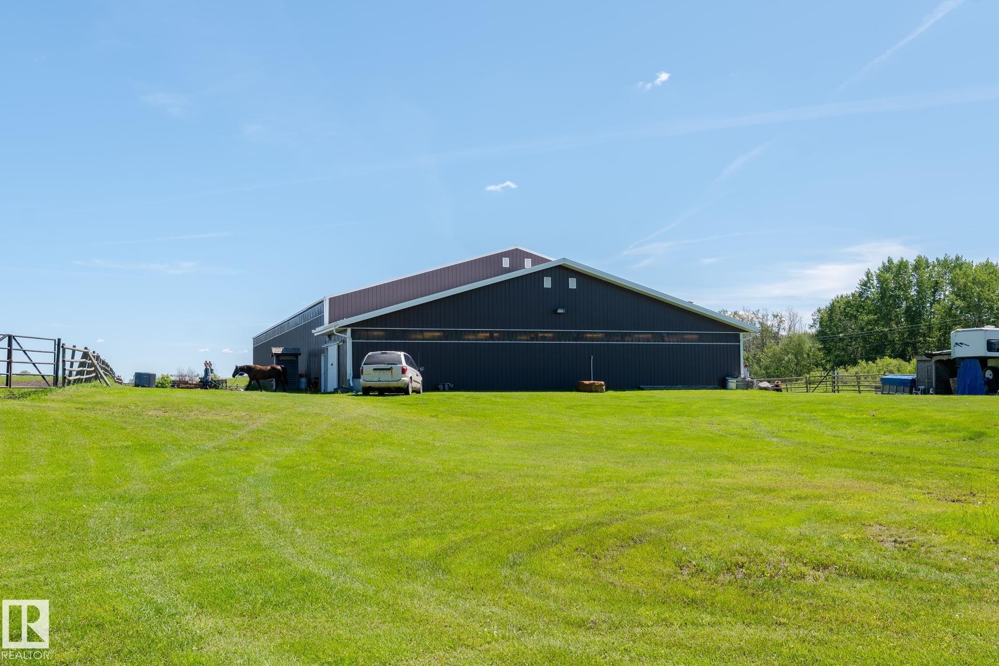 Expansive green lawn fronting a large dark-sided outbuilding with a brown roof - 860 41 Avenue, Edmonton, AB