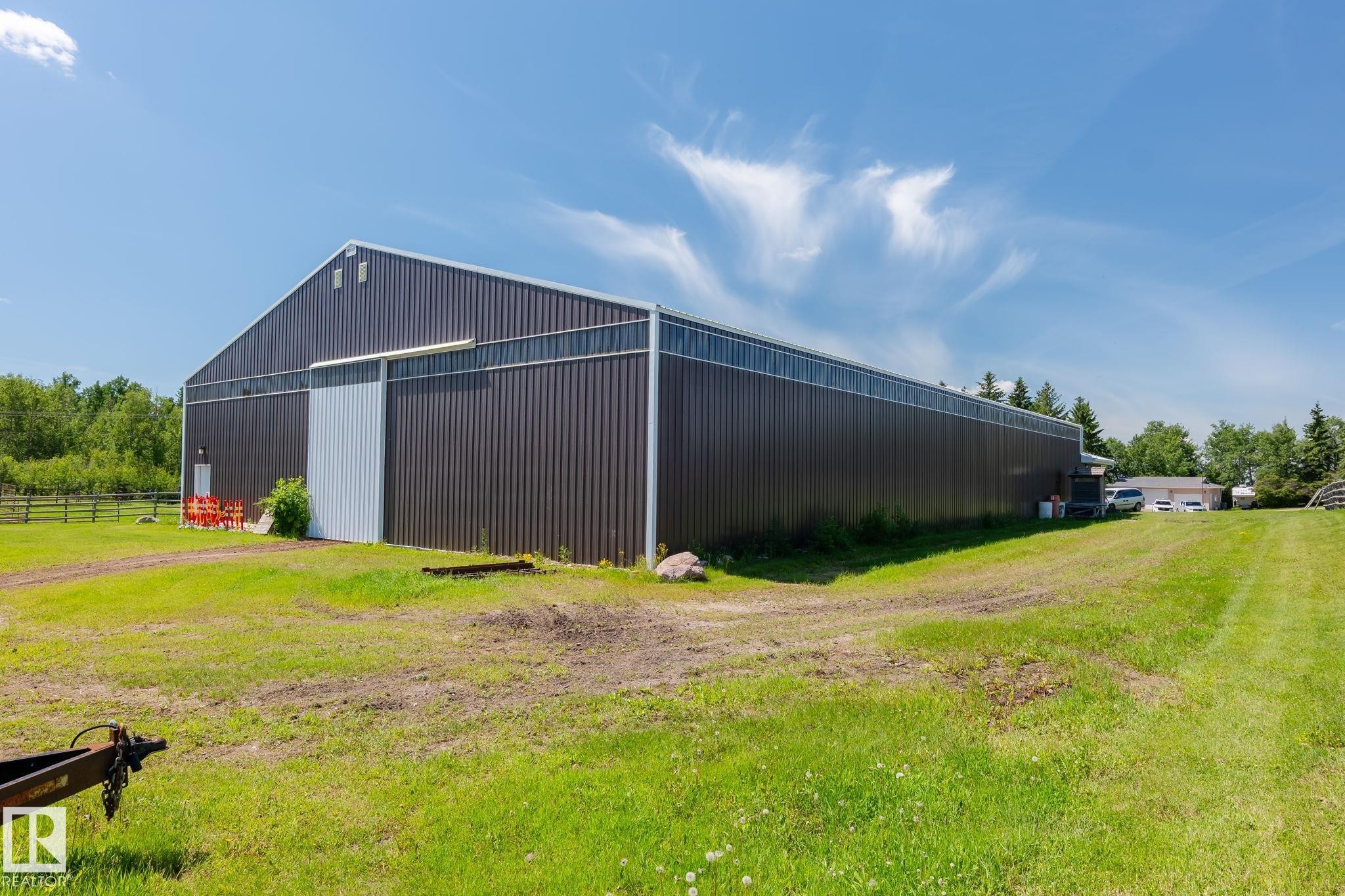 Large-scale agricultural building featuring corrugated metal siding, a prominent sliding bay door, and extensive clerestory windows - 860 41 Avenue, Edmonton, AB