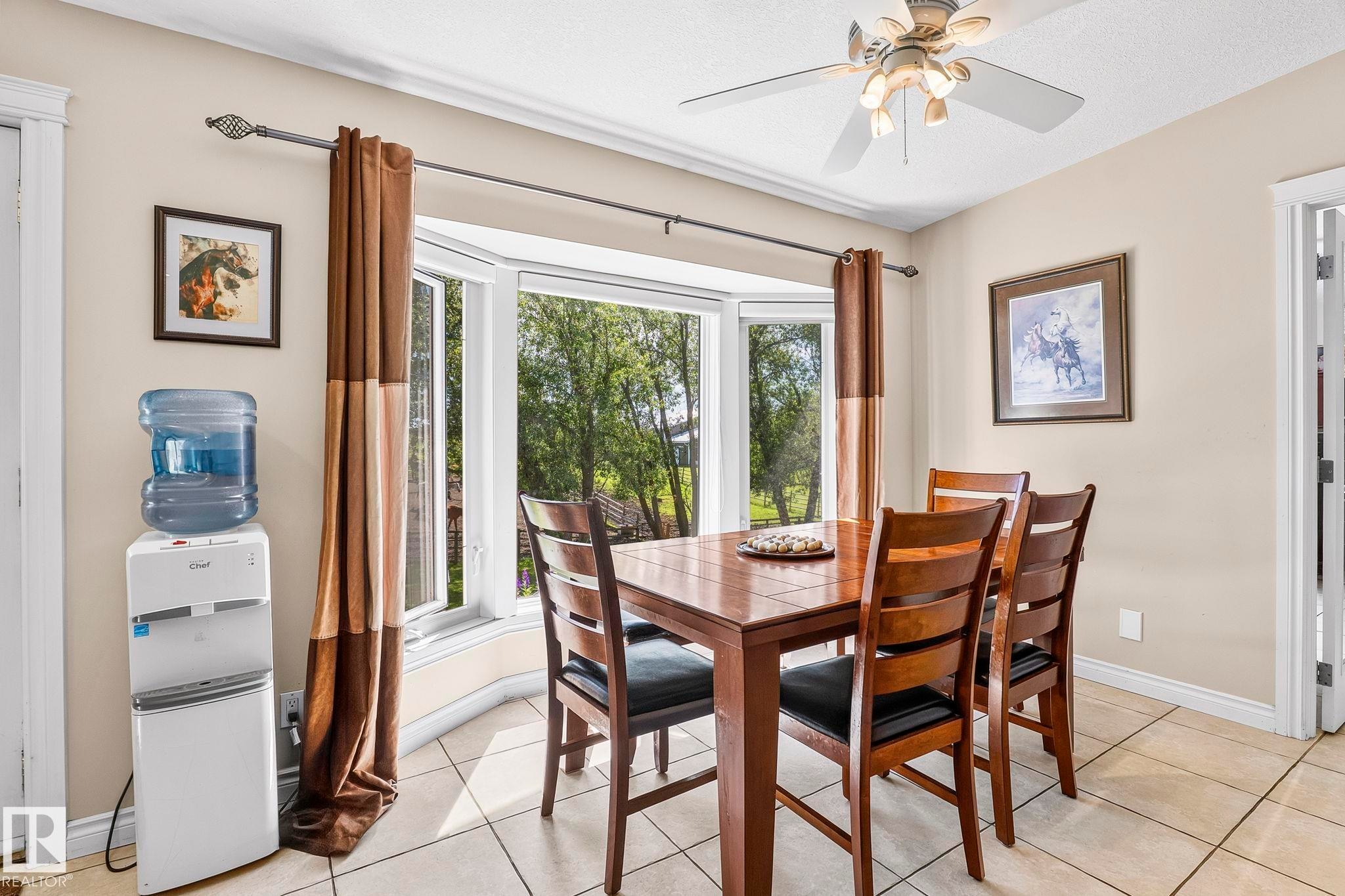 Dining area featuring a bay window, ceiling fan, and tiled flooring - 860 41 Avenue, Edmonton, AB