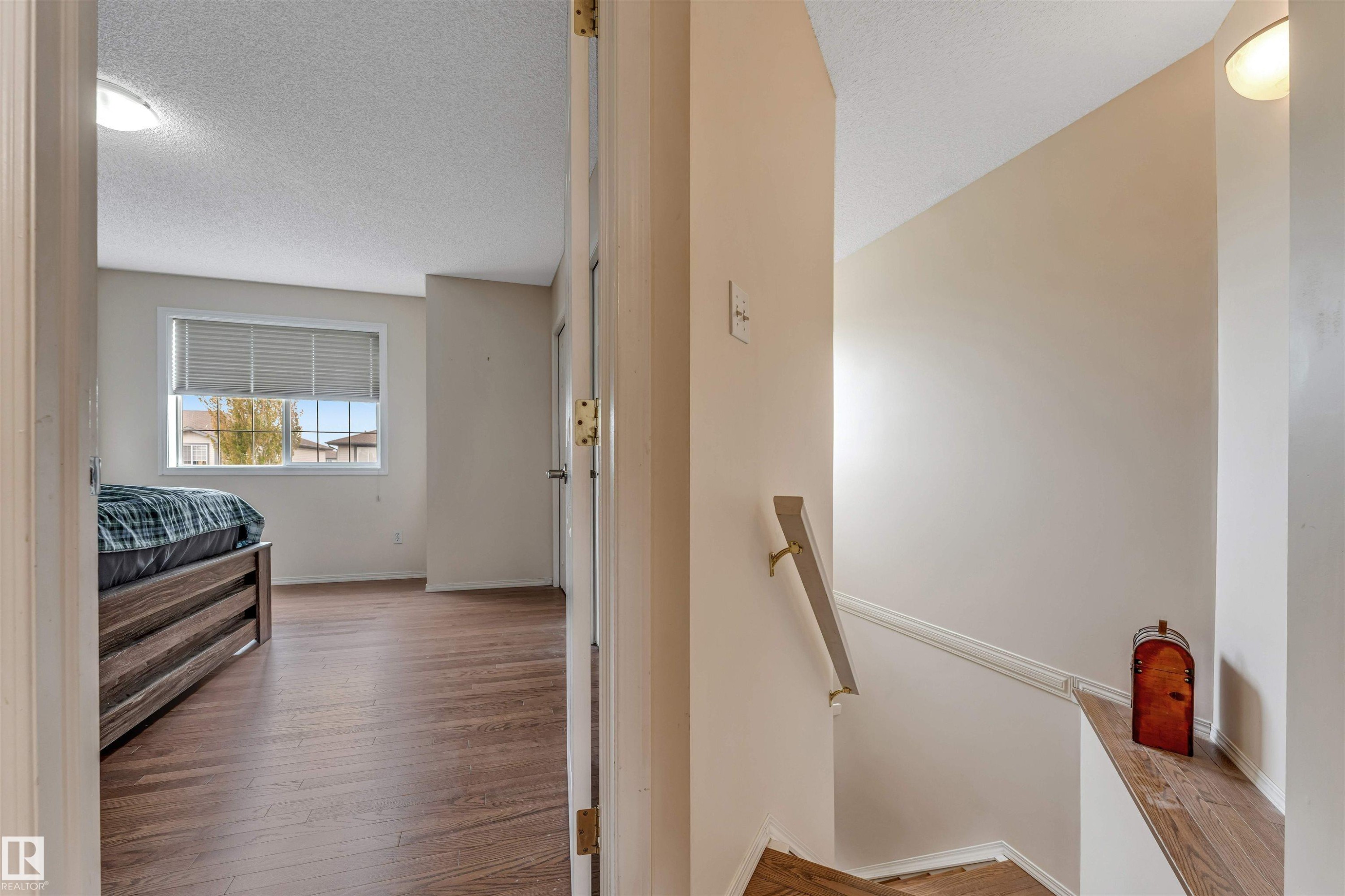 Room featuring wood-finish flooring, a window with horizontal blinds, and a flush mount ceiling light - 3032 31 Avenue, Edmonton, AB - Indoor Photo Showing Other Room